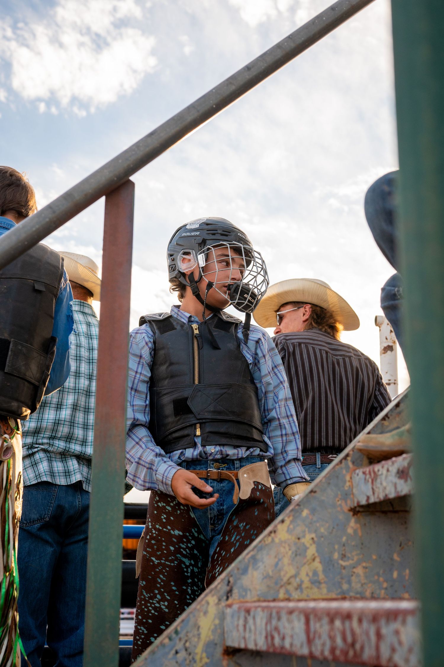 A young boy dressed in a vest and a helmet poses behind a staircase in Laramie, Wyoming.