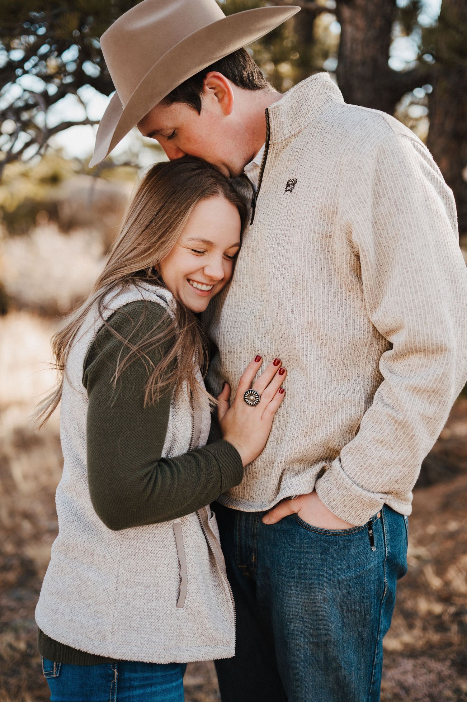 A couple shares intimate moments outdoors in a series of romantic photos wearing casual sweaters and jeans.