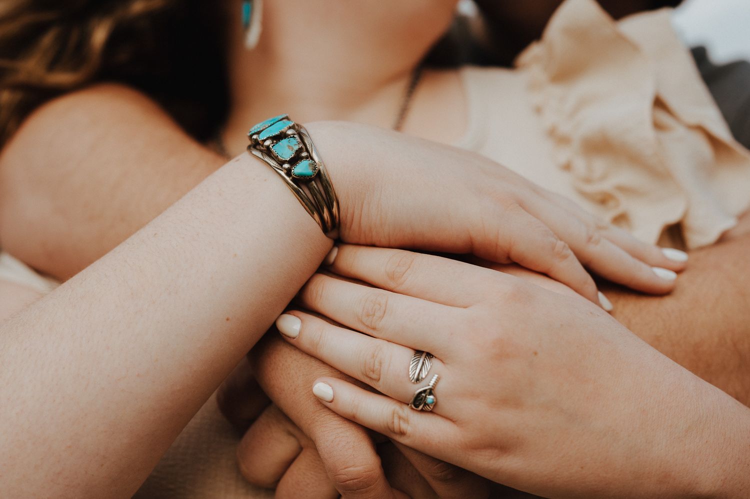 Close-up view of hands with wedding rings exchanging vows during an intimate ceremony.