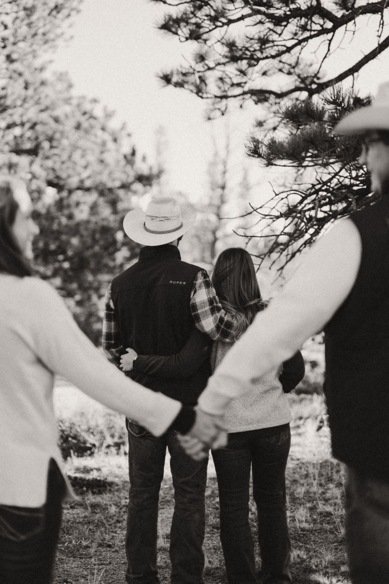 A black and white photo series showing multiple people standing in a line outdoors with trees in the background.
