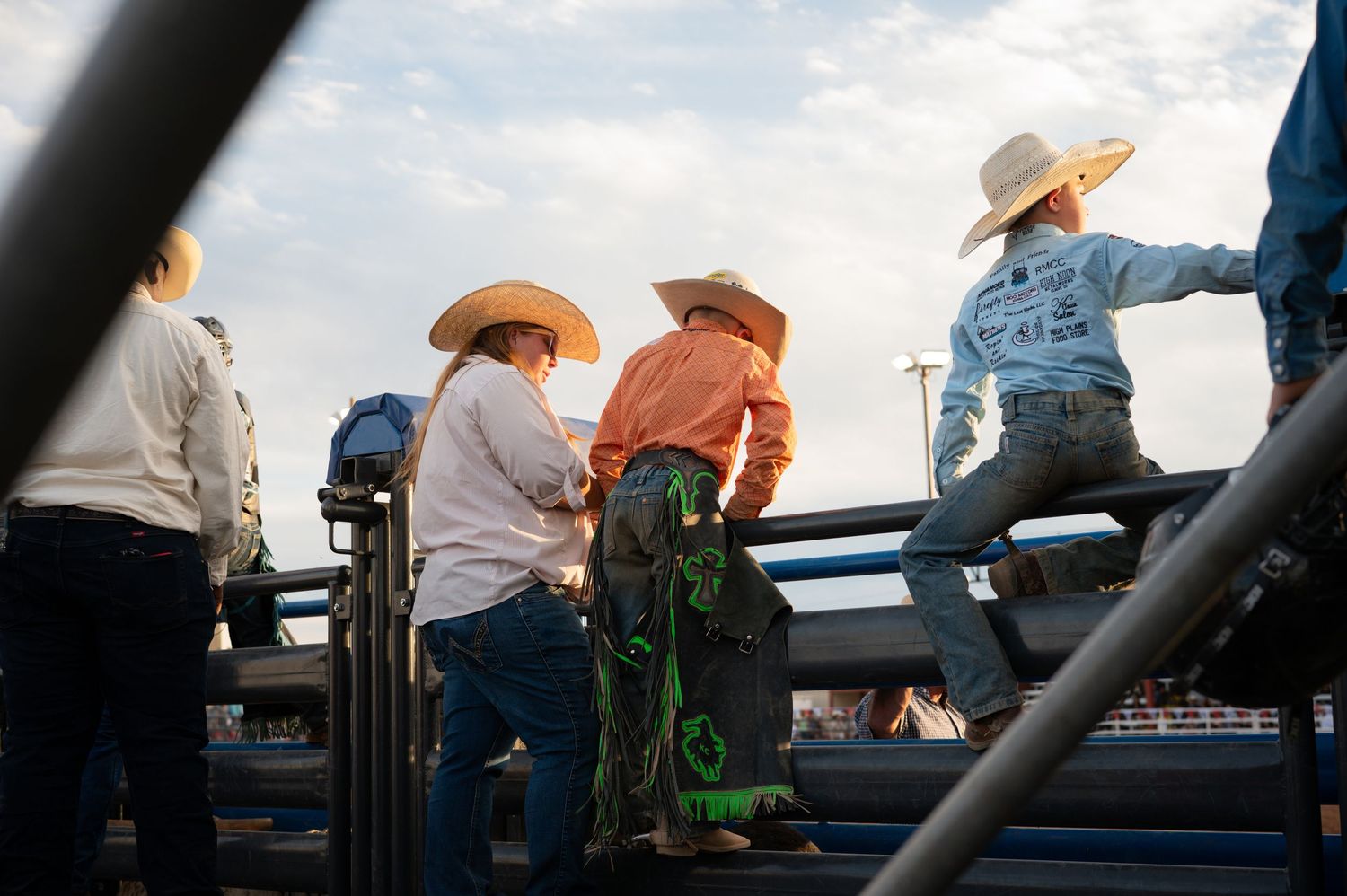 Two young boys and a woman stand near the bucking stock chutes at the Albany County Fairgrounds.