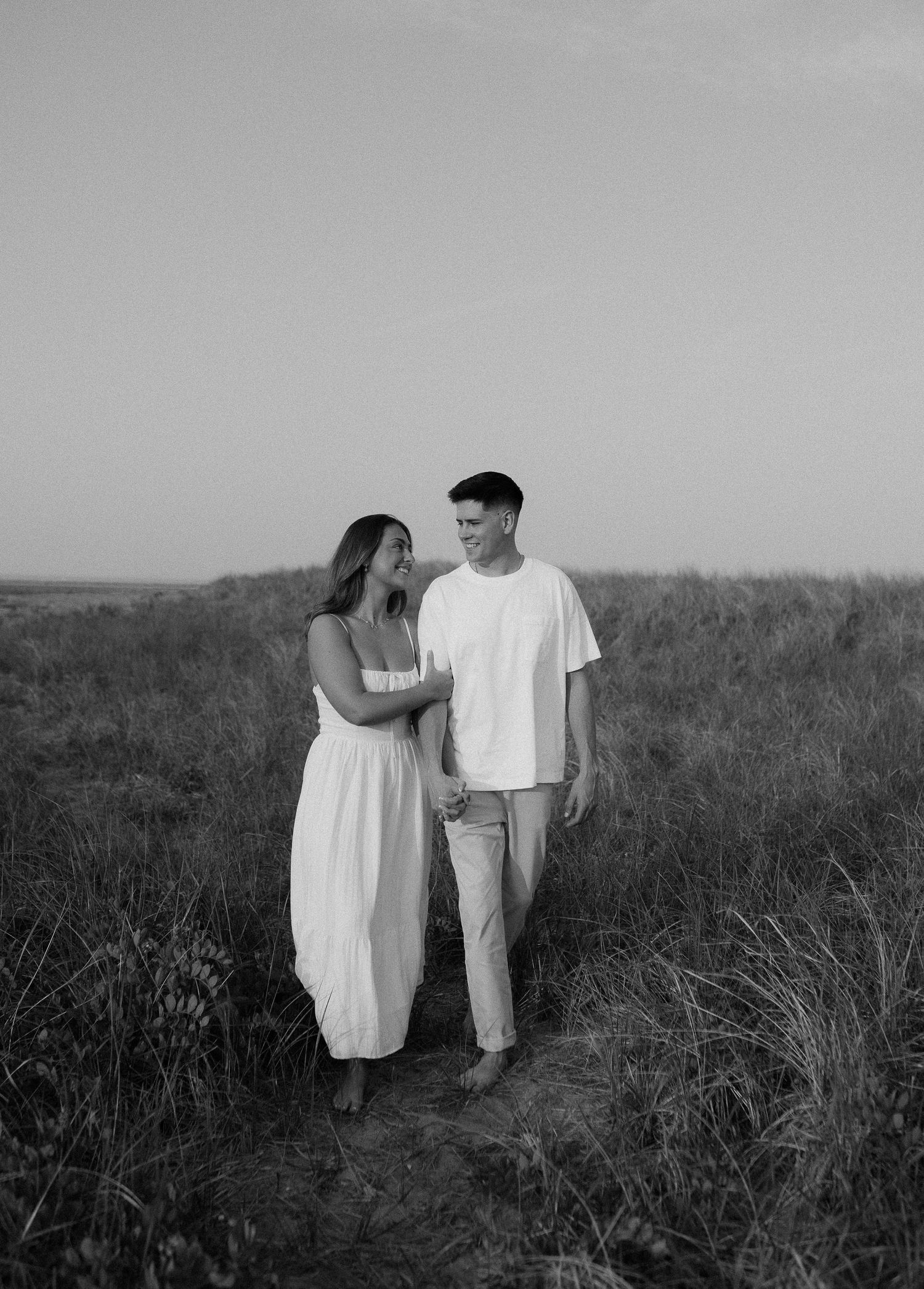 Black and white portrait of couple walking together on nature trail.