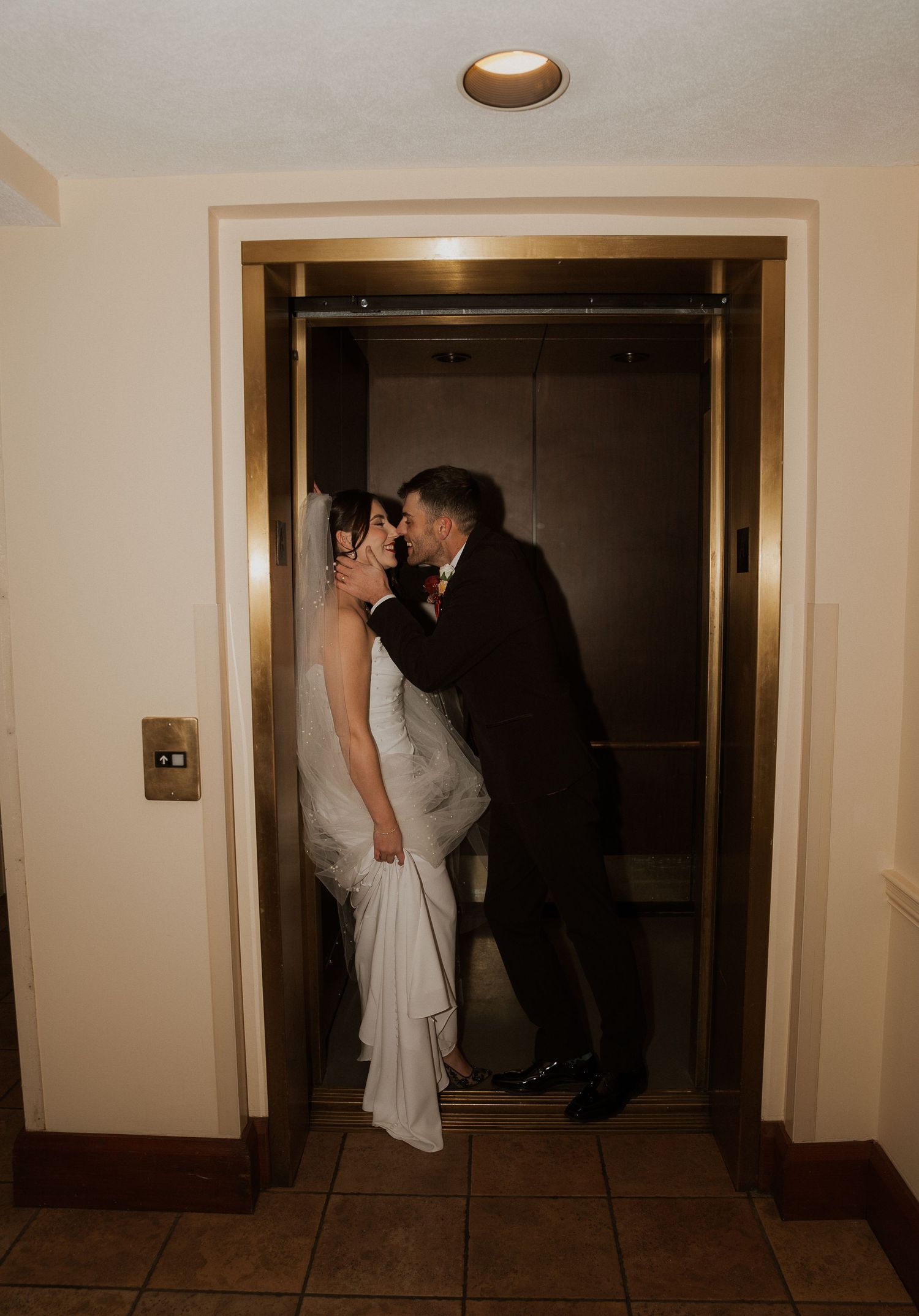 A couple in formal wedding attire share intimate moments in a dimly lit hallway through a sequence of romantic photos.