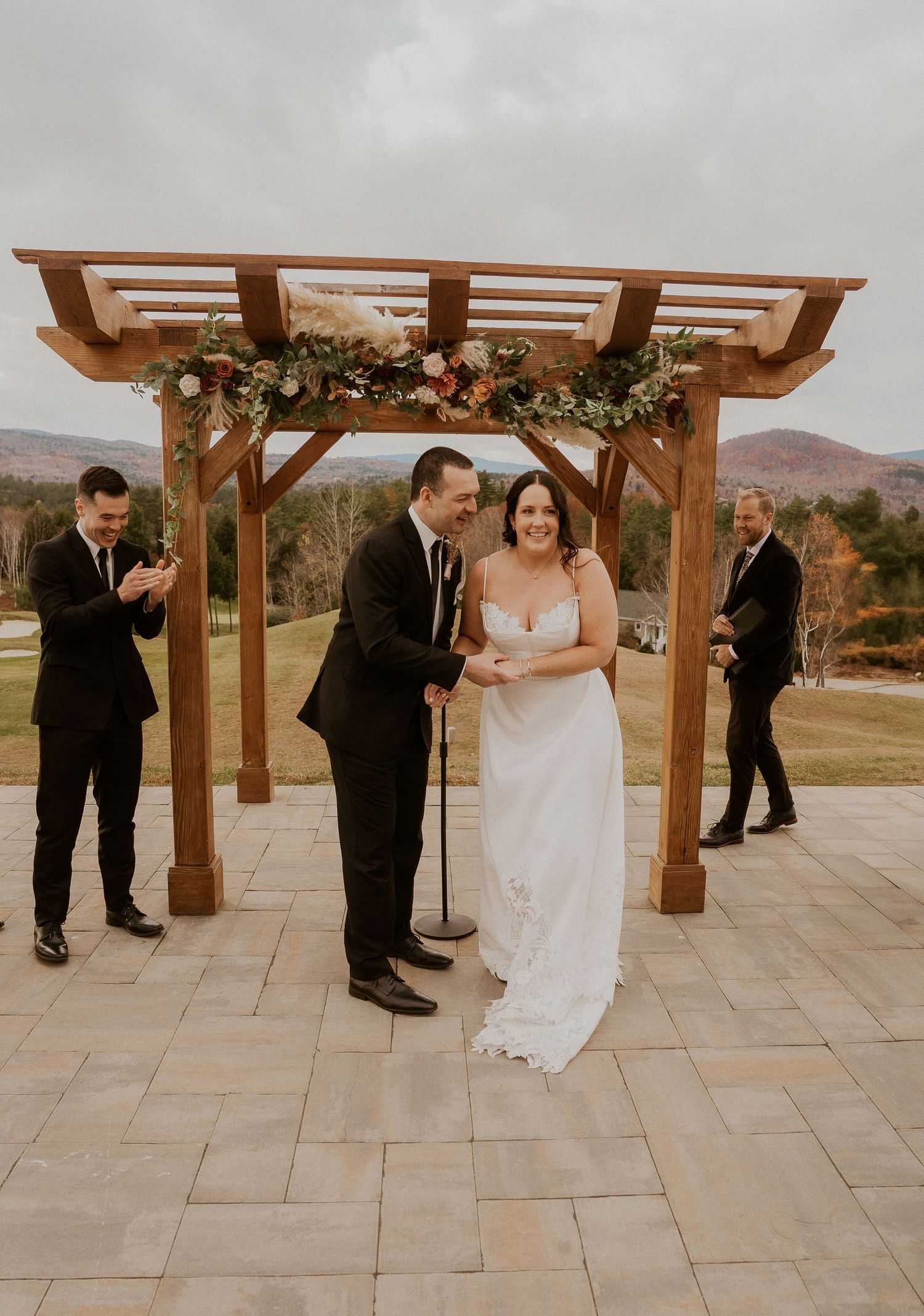 A romantic first dance sequence captured at an outdoor wedding venue with wooden pergolas and mountain views in the background.