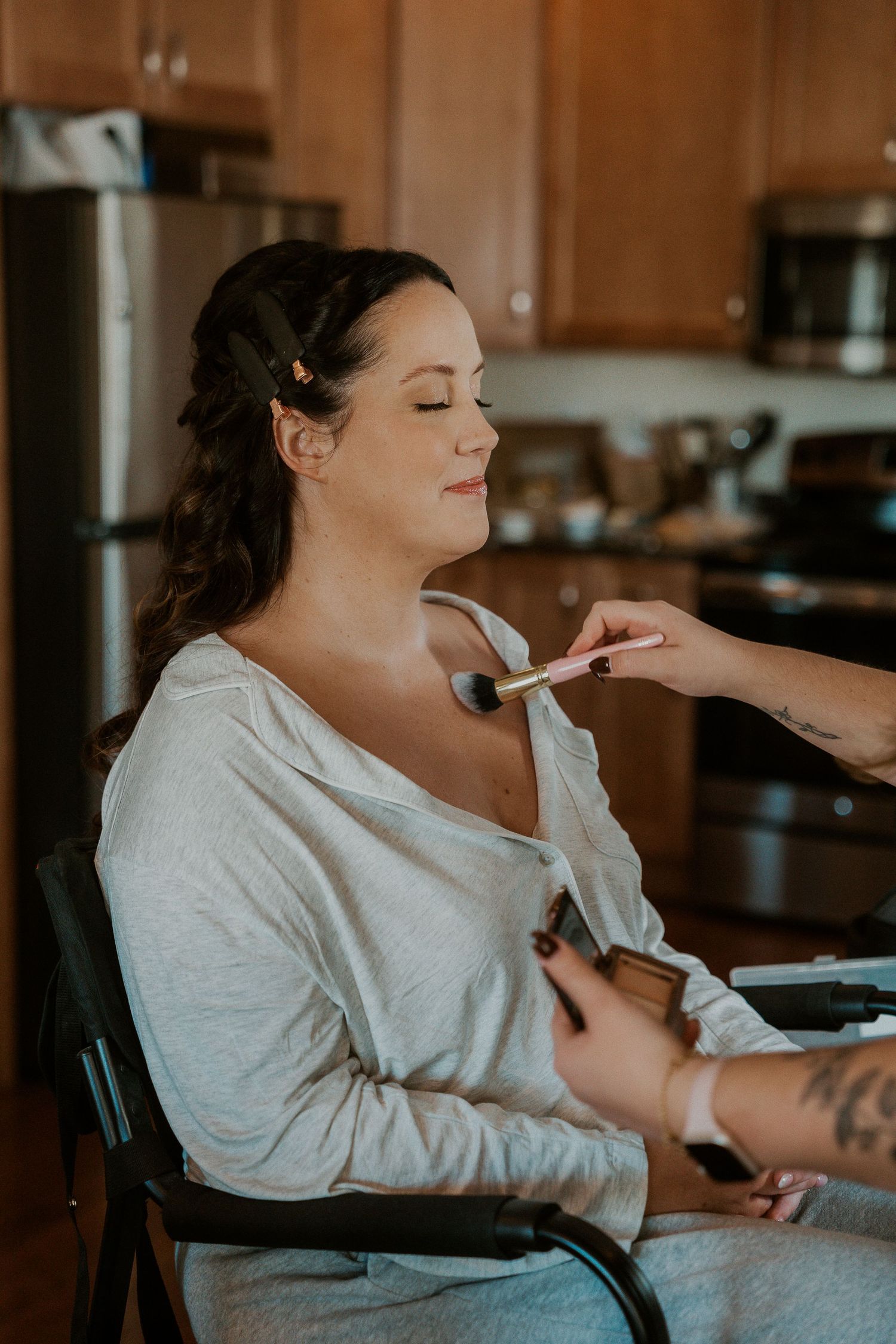 A person in a white shirt gets their makeup applied in a series of progressive shots showing the application process.