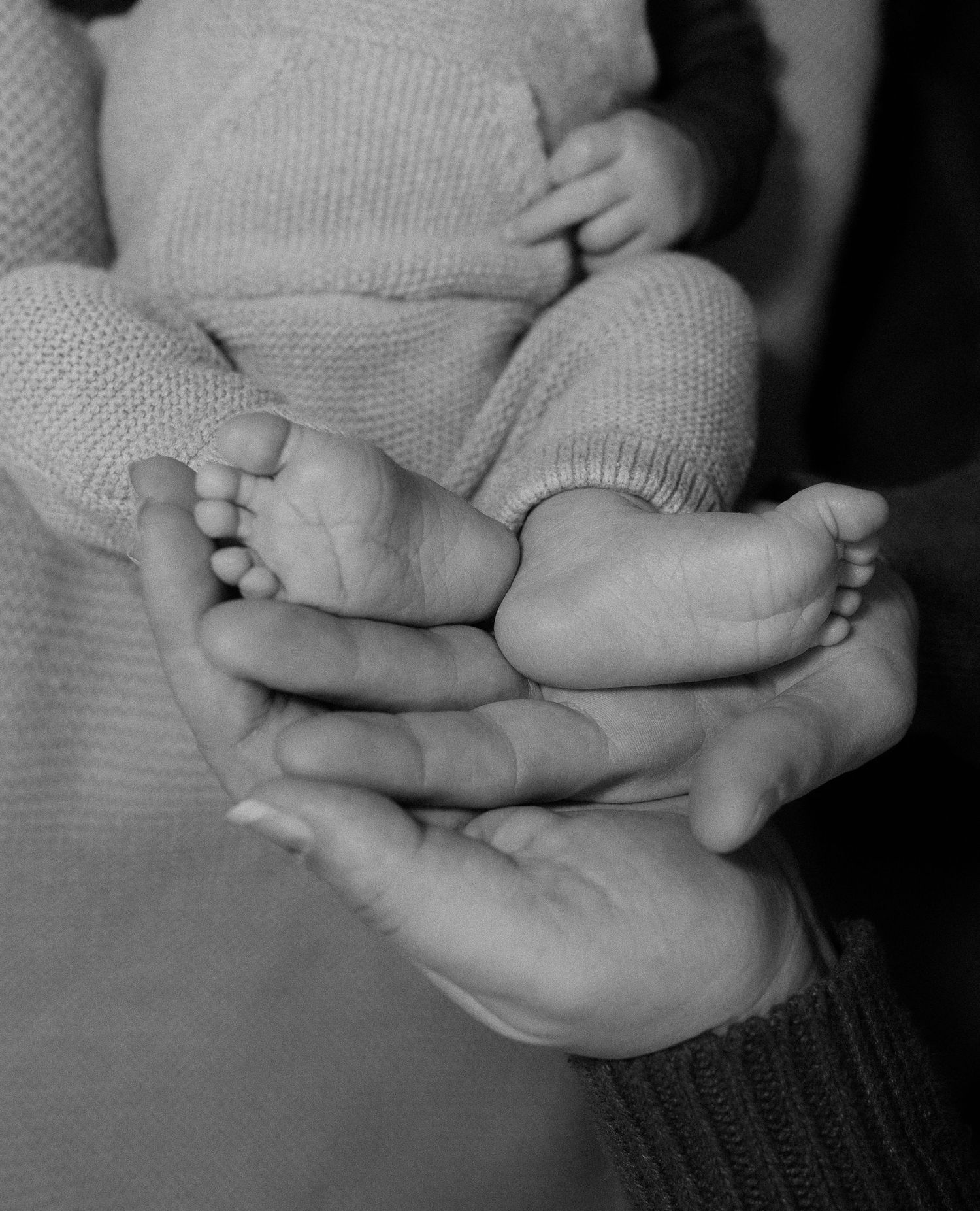 Black and white series of intimate hand-holding moments between parent and baby.