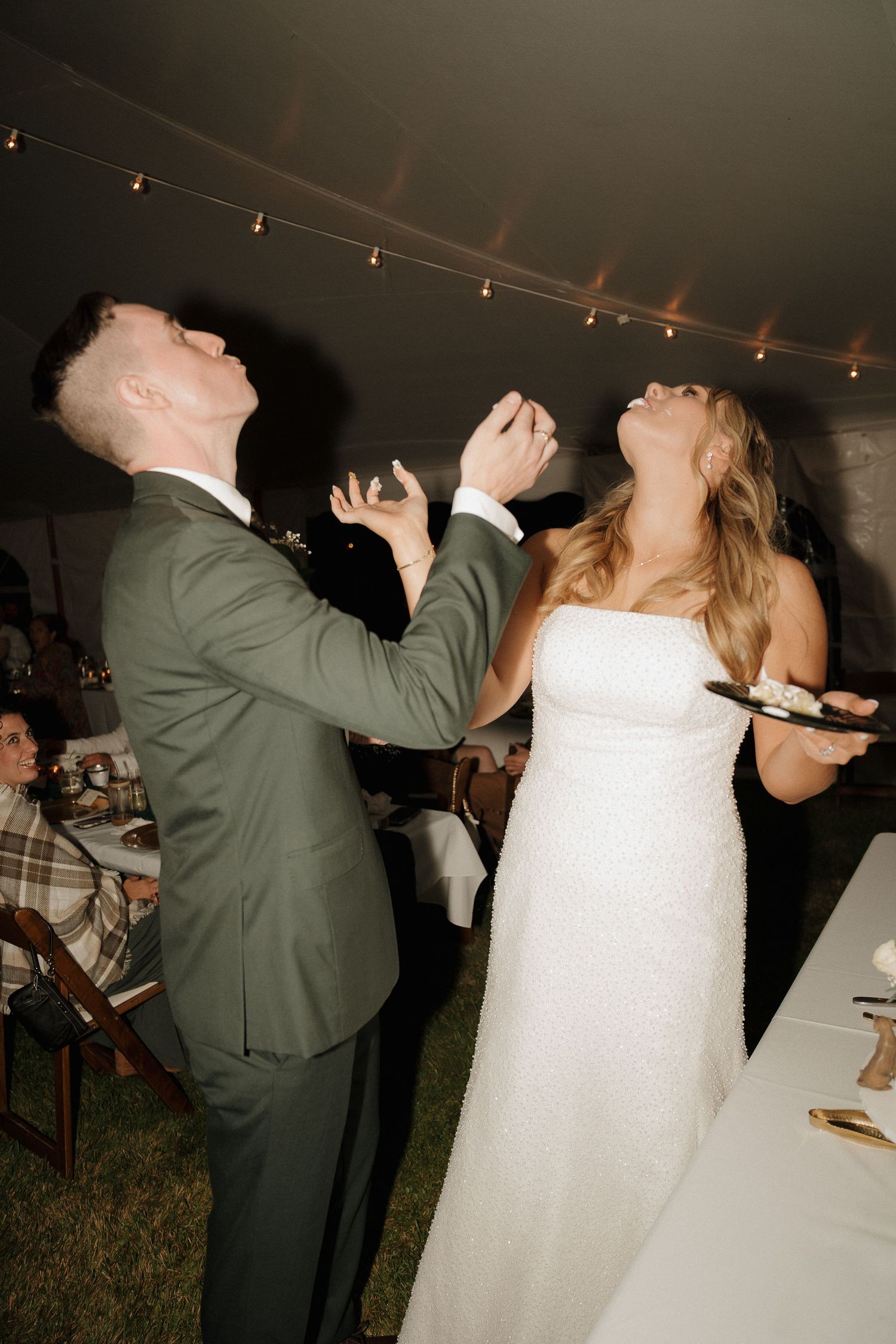 A couple laughs joyfully during their wedding cake tasting moment.