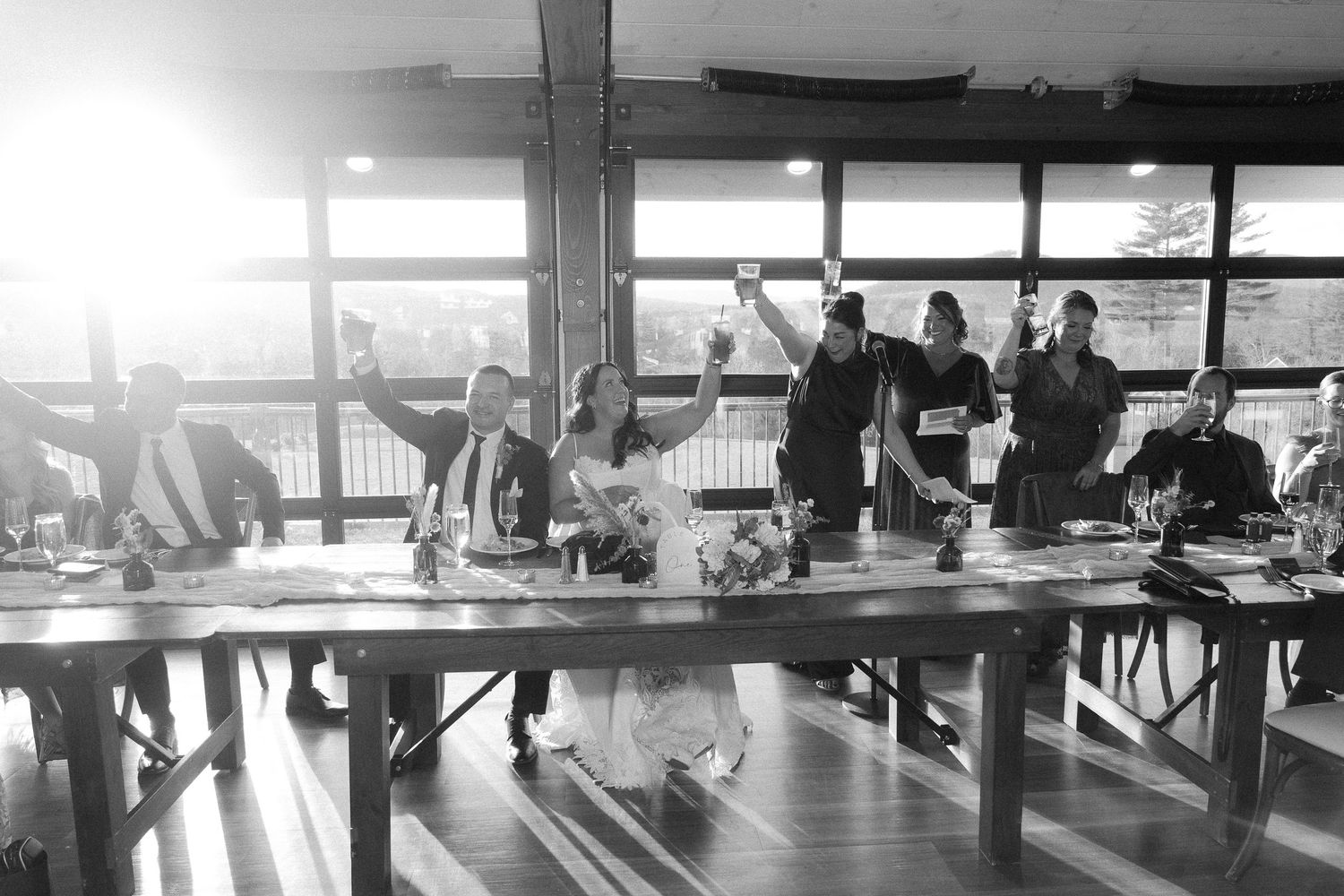 Modern indoor reception space with floor-to-ceiling windows offering panoramic views of mountains at sunset.