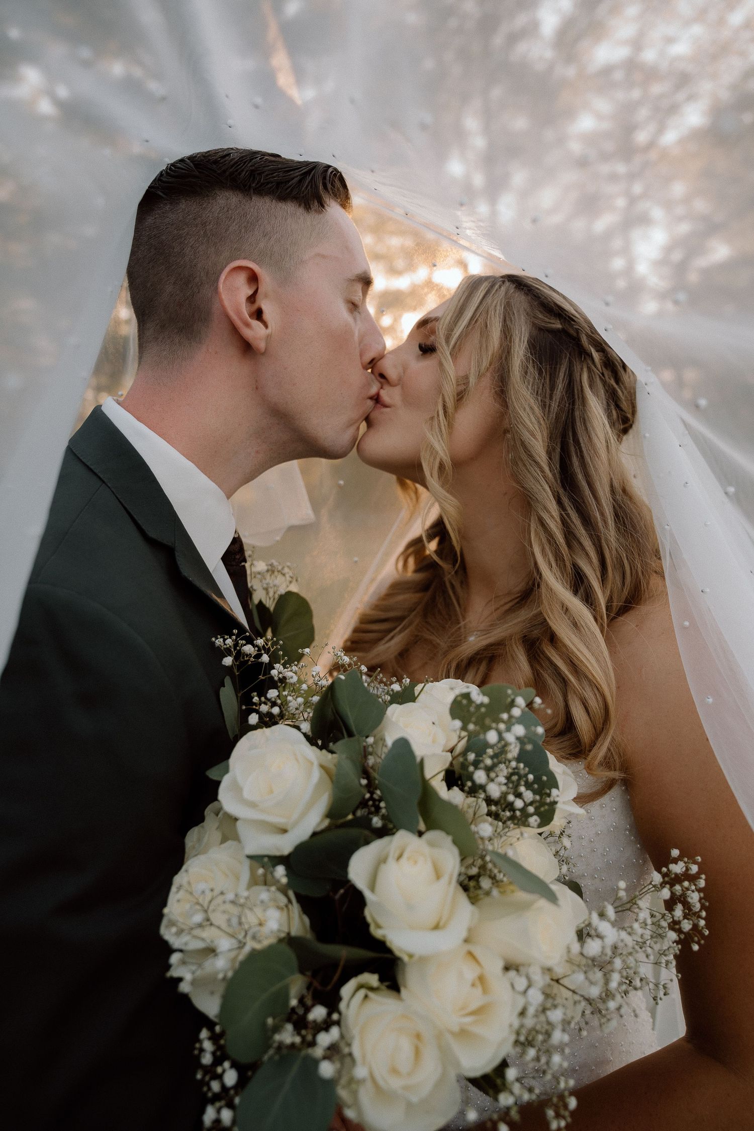Close-up wedding photos capturing romantic moments with white rose bouquet details.