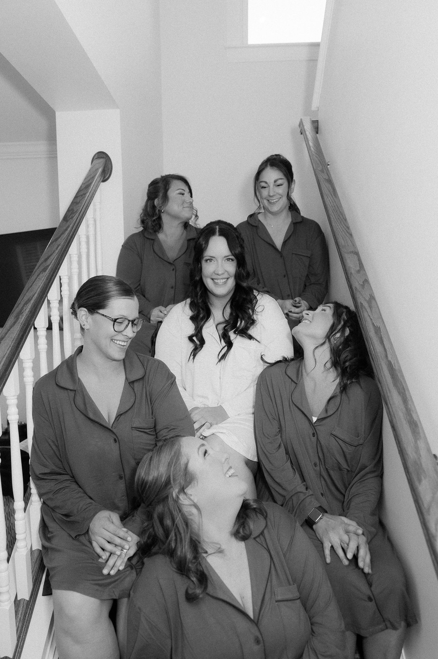 A sequence of black and white photos showing a group laughing together while wearing matching robes.