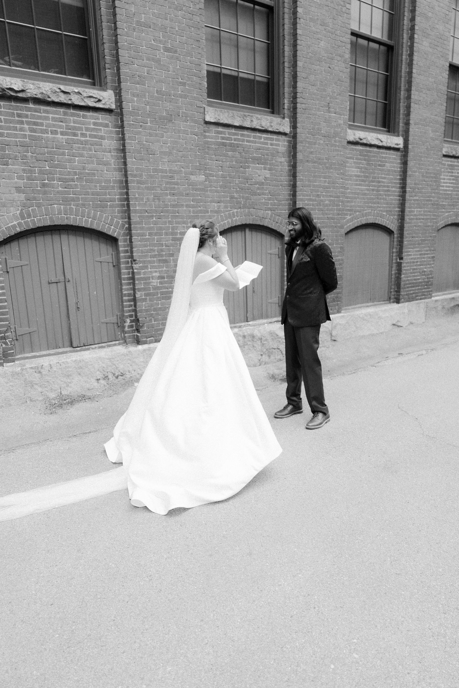 Black and white photos of a couple dancing near an industrial brick building.