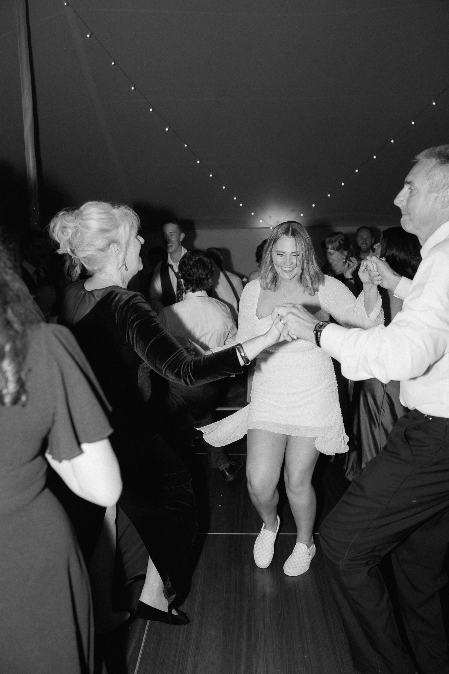 Black and white photos capture lively dancing at a wedding reception.