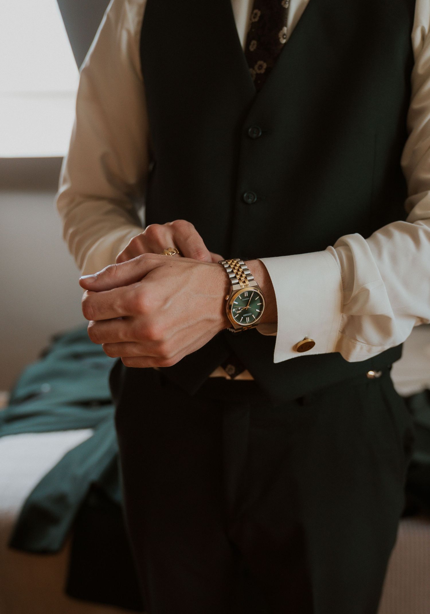 Details of formal wear and accessories being adjusted before an event.