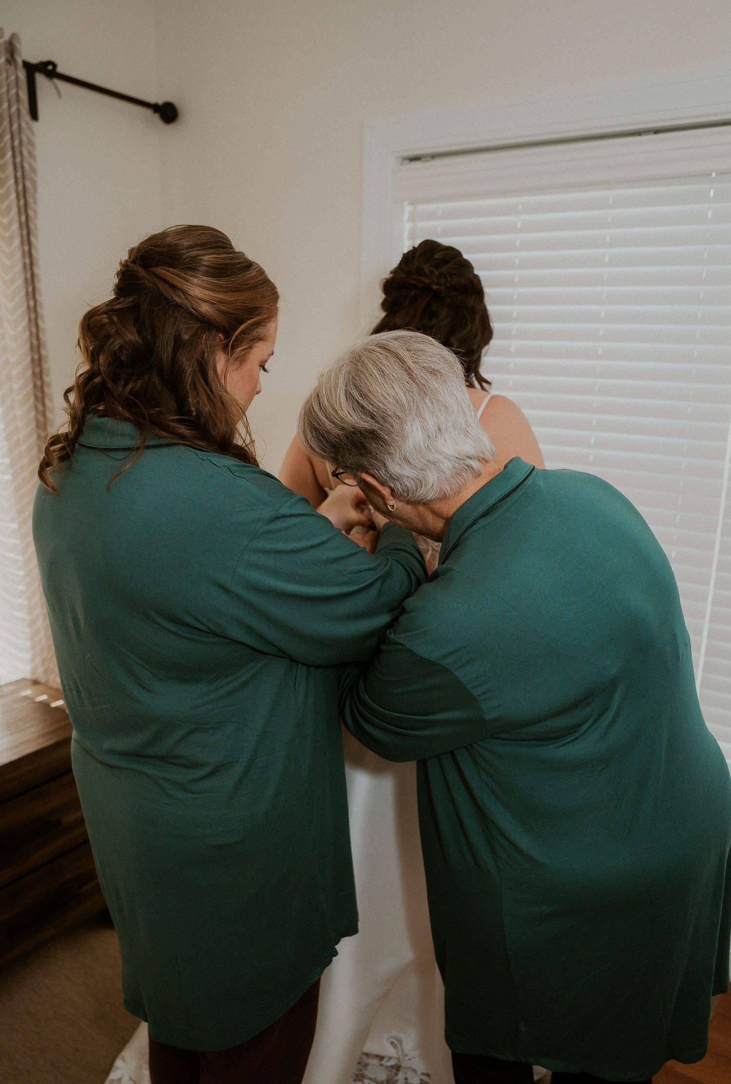 A sequence of photos showing two people in green jackets embracing and supporting each other in a room.