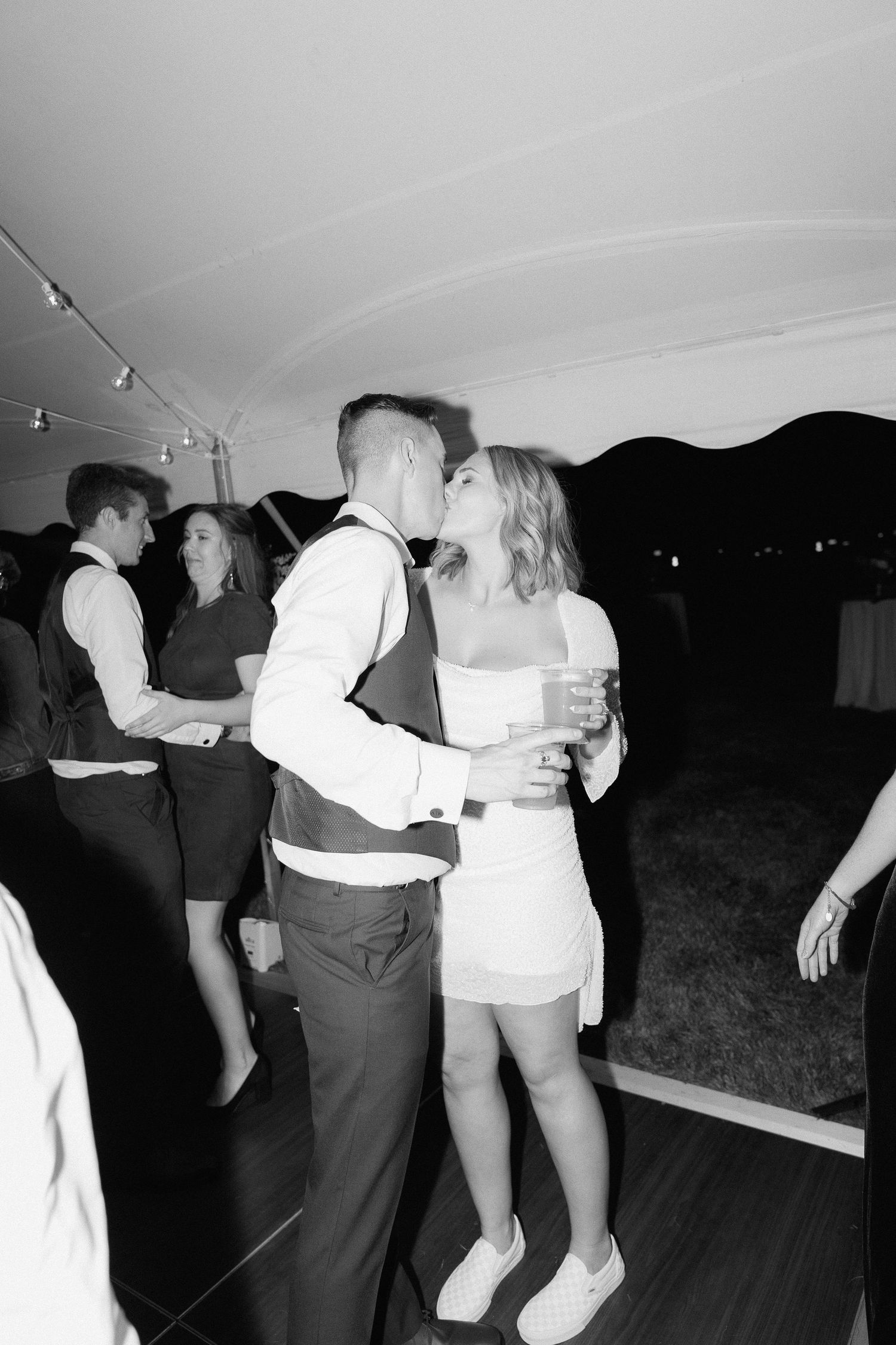 Black and white photos of wedding guests dancing and celebrating on a dance floor.