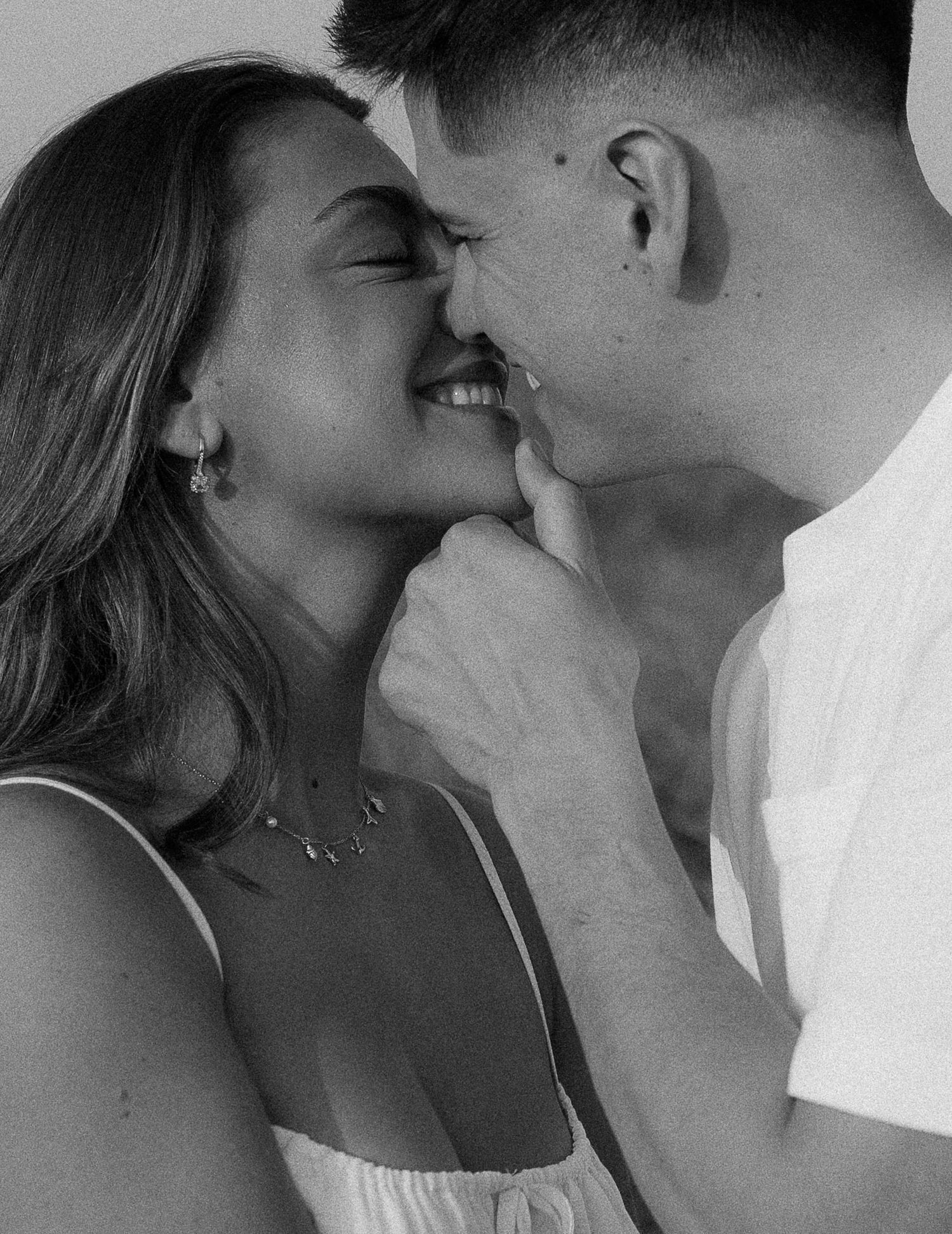 Intimate black and white portrait of a couple sharing a tender romantic moment.