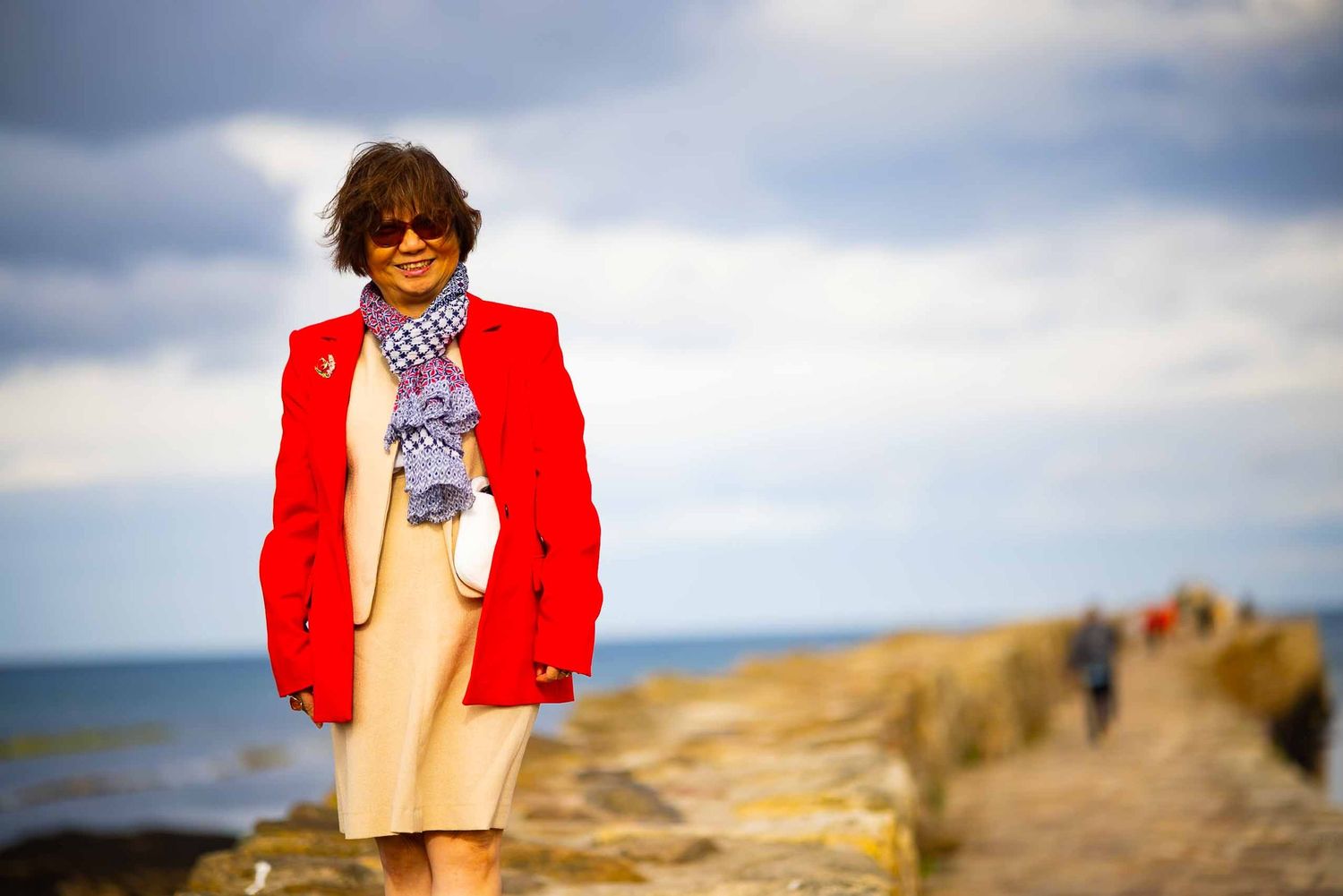professional female portrait by the sea, on the pier in st andrews, scotland with vivid colours and emotions. Shot by Gerard Su Photography.