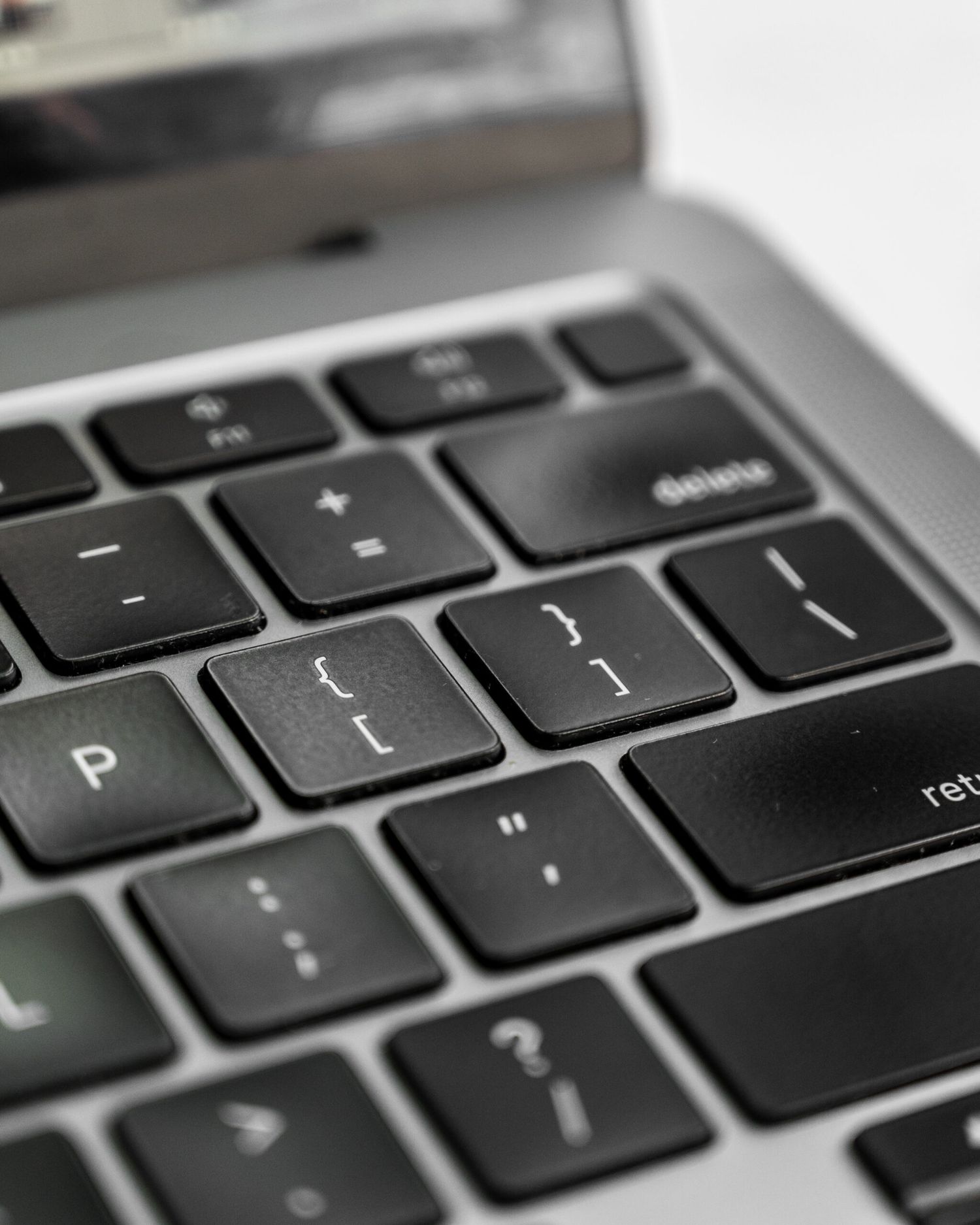 Close-up of a modern laptop keyboard showing black keys with white lettering.