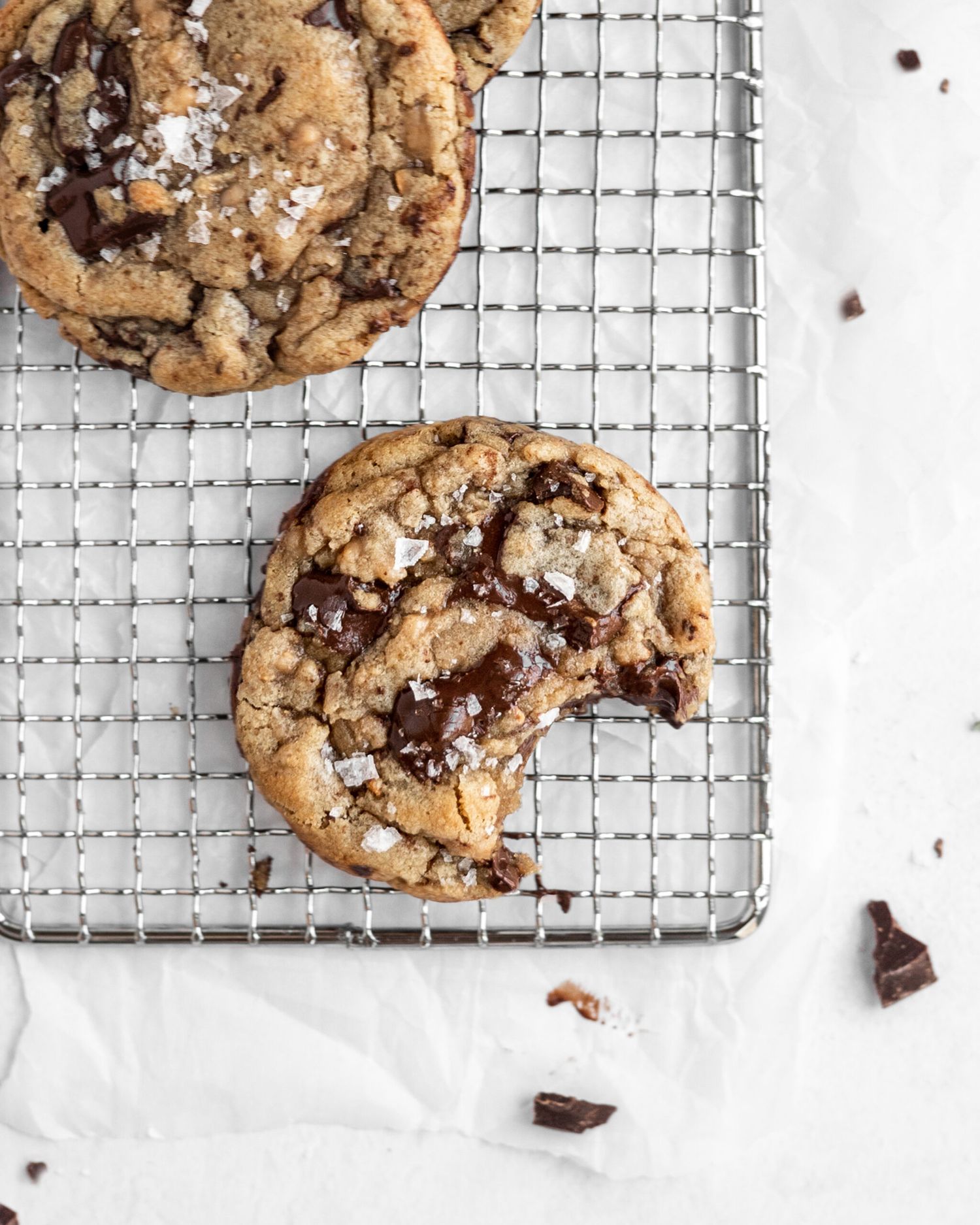 Close-up shot of freshly baked chocolate chunk cookies cooling on a wire baking rack.