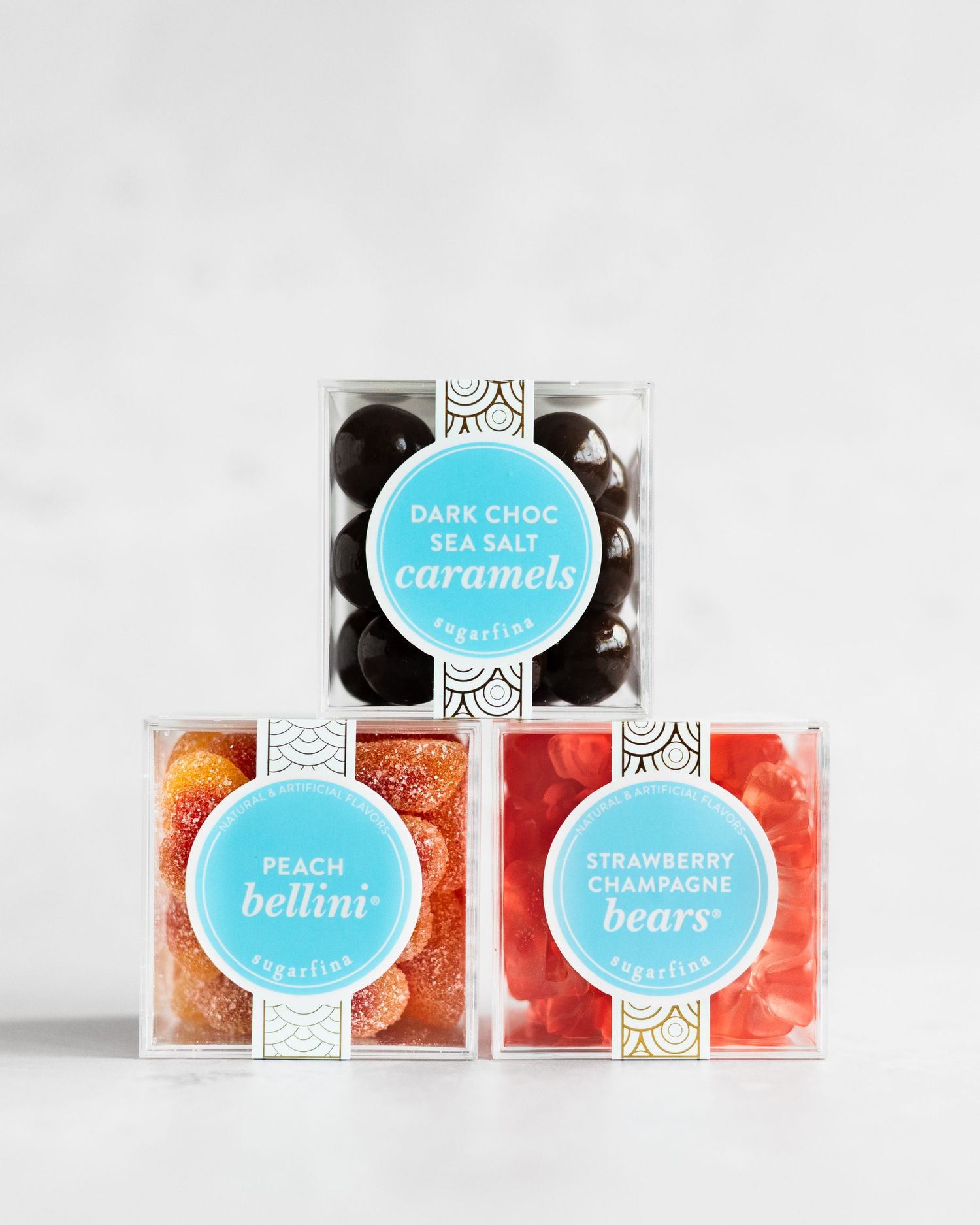 Colorful candy boxes displaying different flavors like caramels, peach, and strawberry bears in elegant packaging.