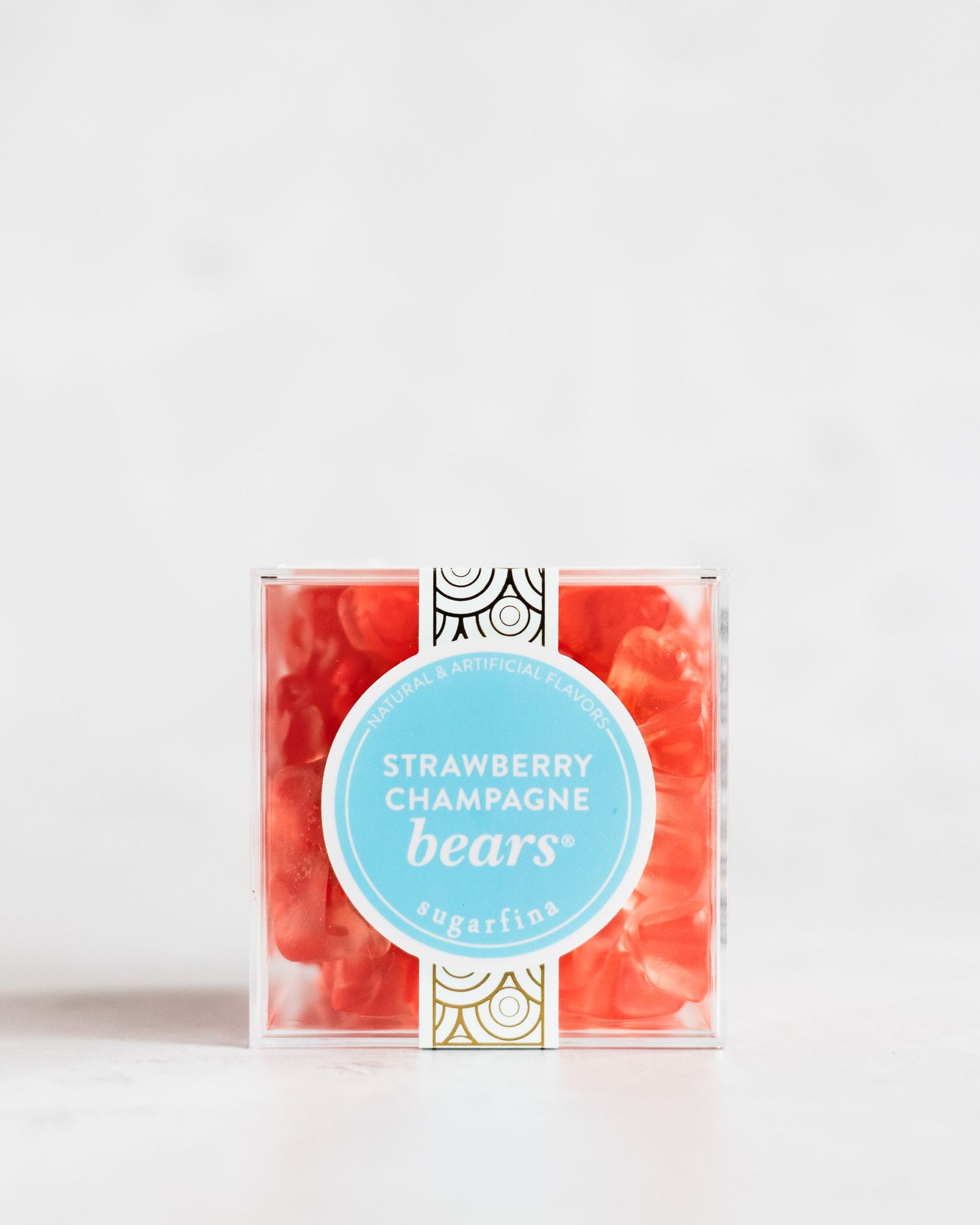 A clear cube box of pink strawberry gummy bears candy on white background.