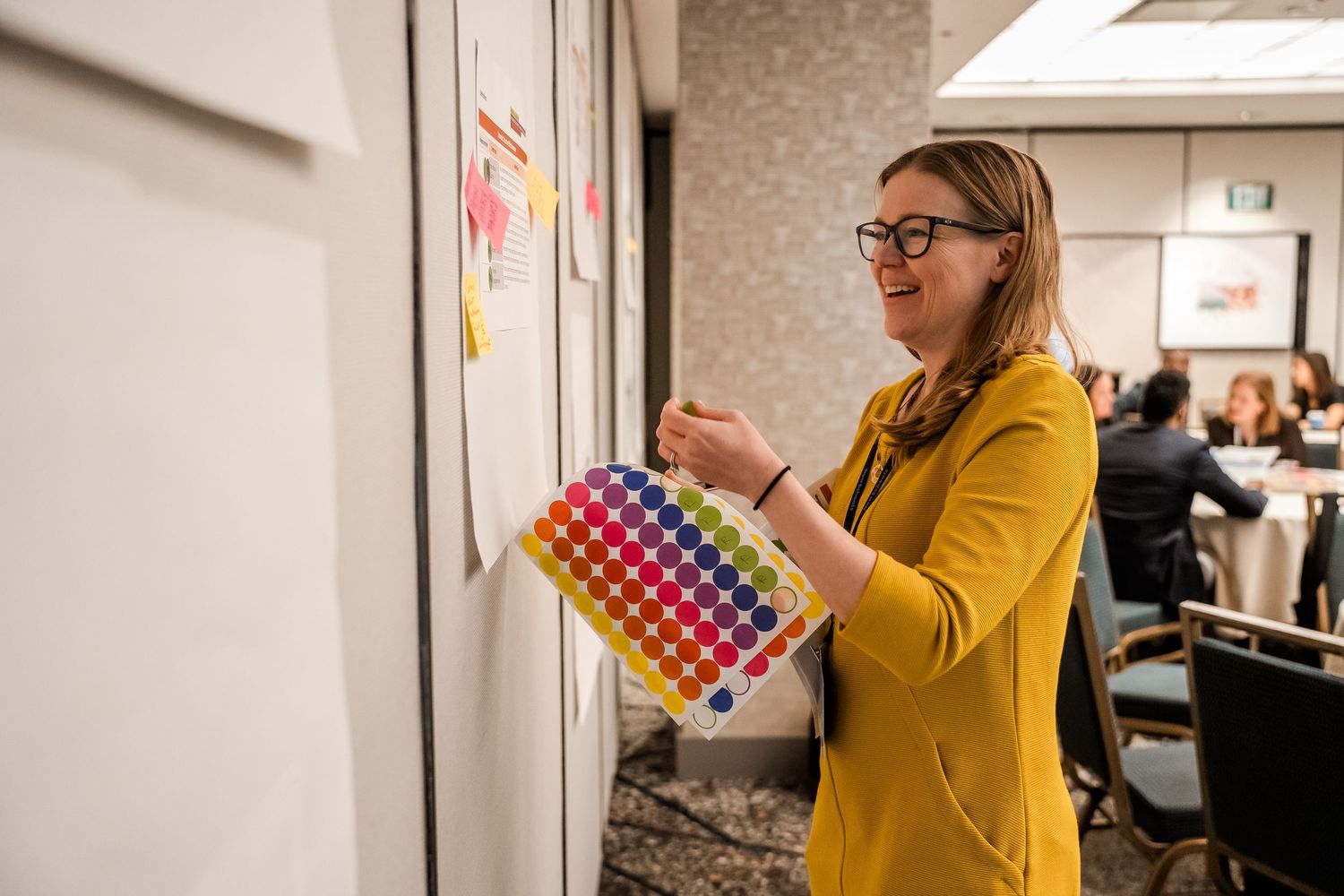 Person holding color swatches or samples in an office hallway for corporate retreat.