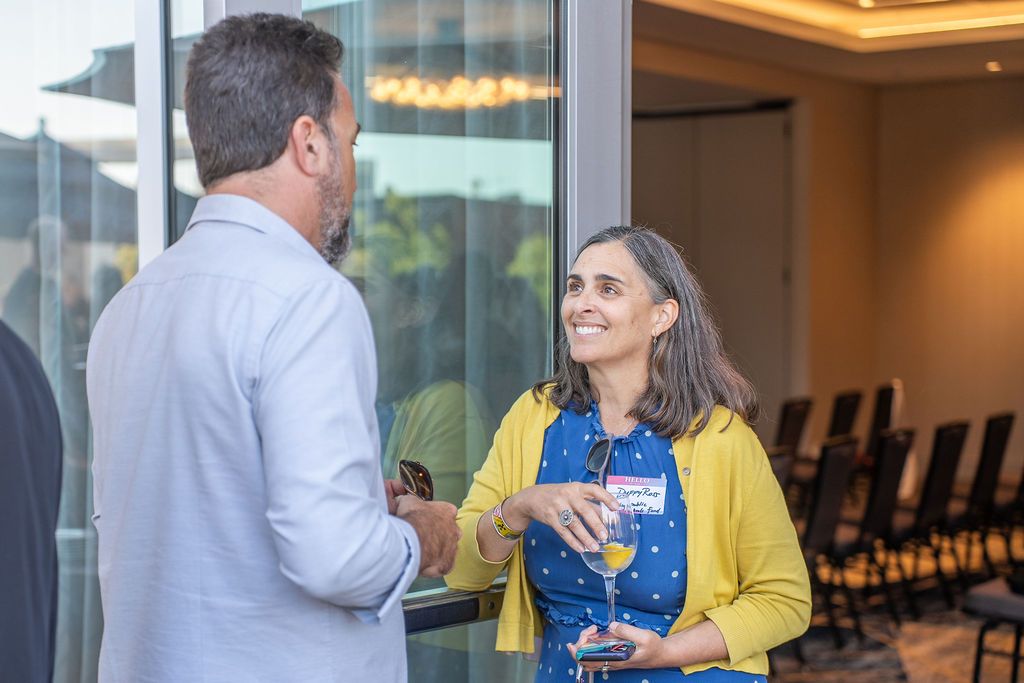A candid conversation between two attendees near the ballroom doors, blending indoor and outdoor event spaces at Residence Inn Berkeley.
