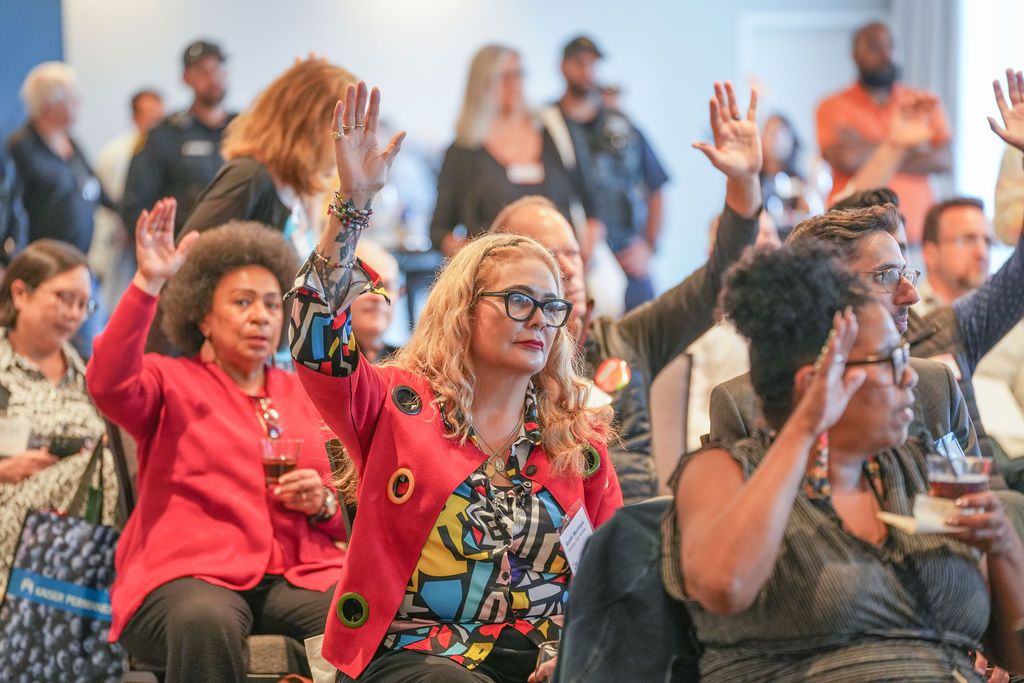 Audience members raise their hands during an interactive moment at the Berkeley Chamber of Commerce annual meeting inside the Residence Inn