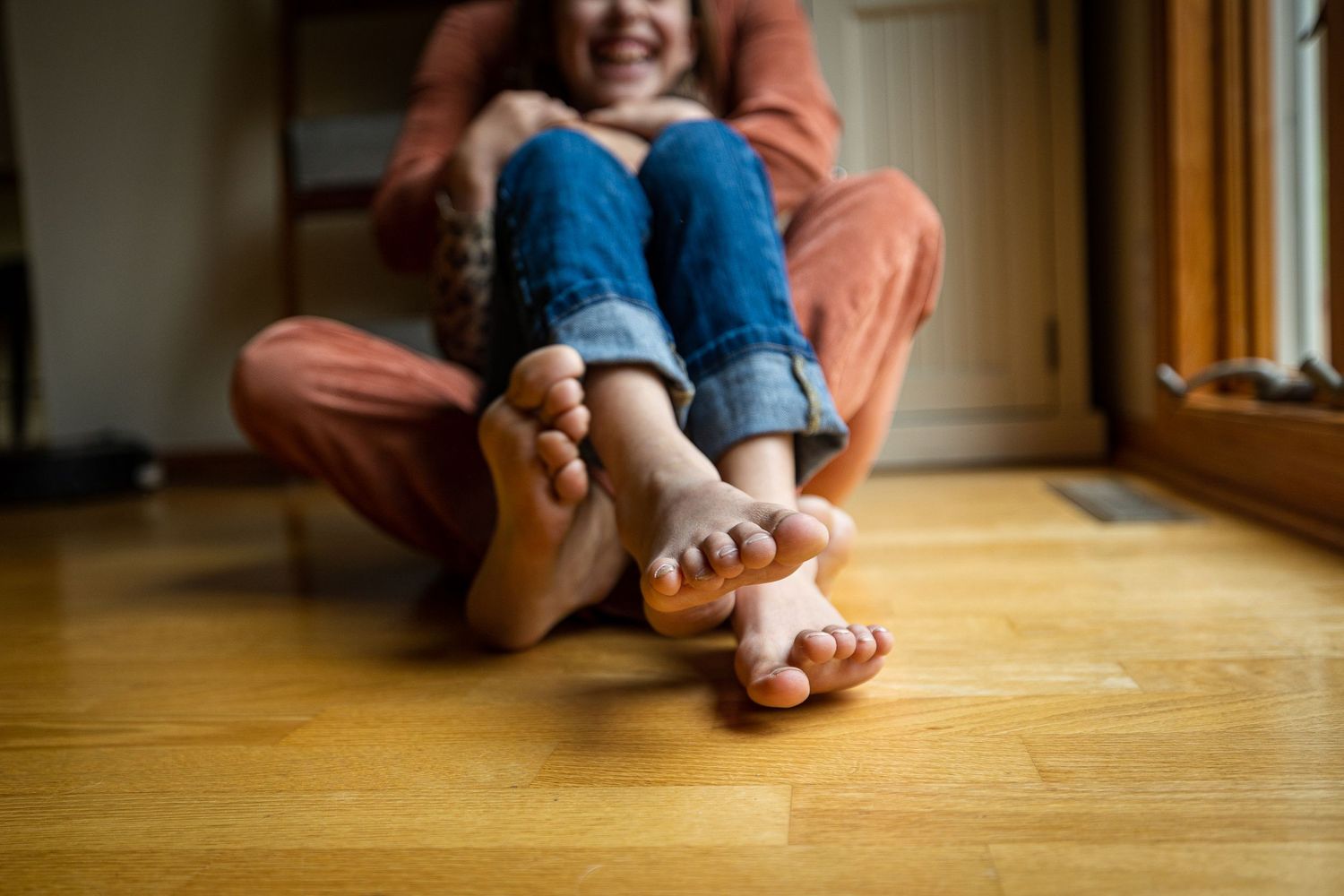 Candid moments of bare feet and relaxation on hardwood floors.