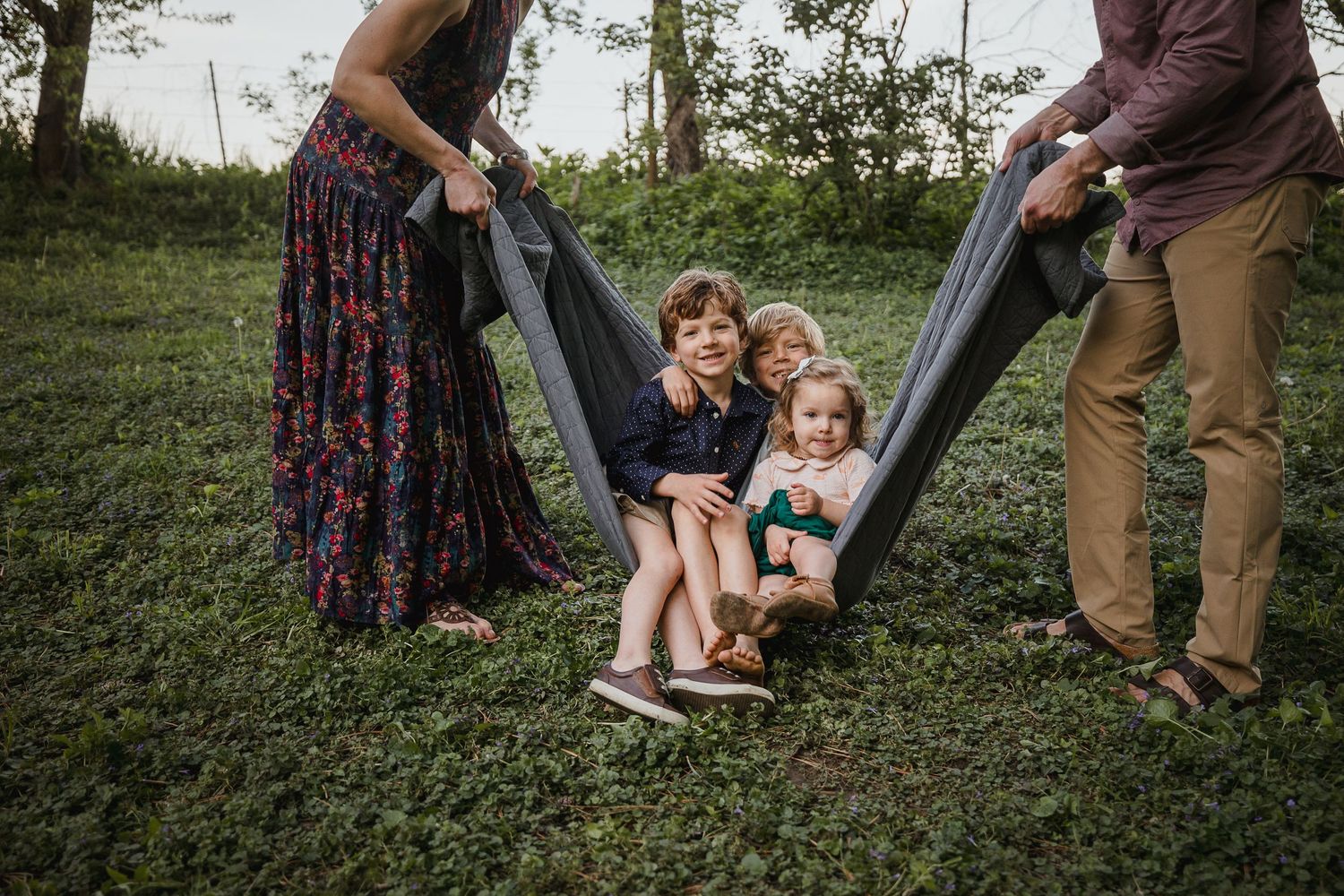 Family interaction moments photographed in sequence on grassy outdoor setting.
