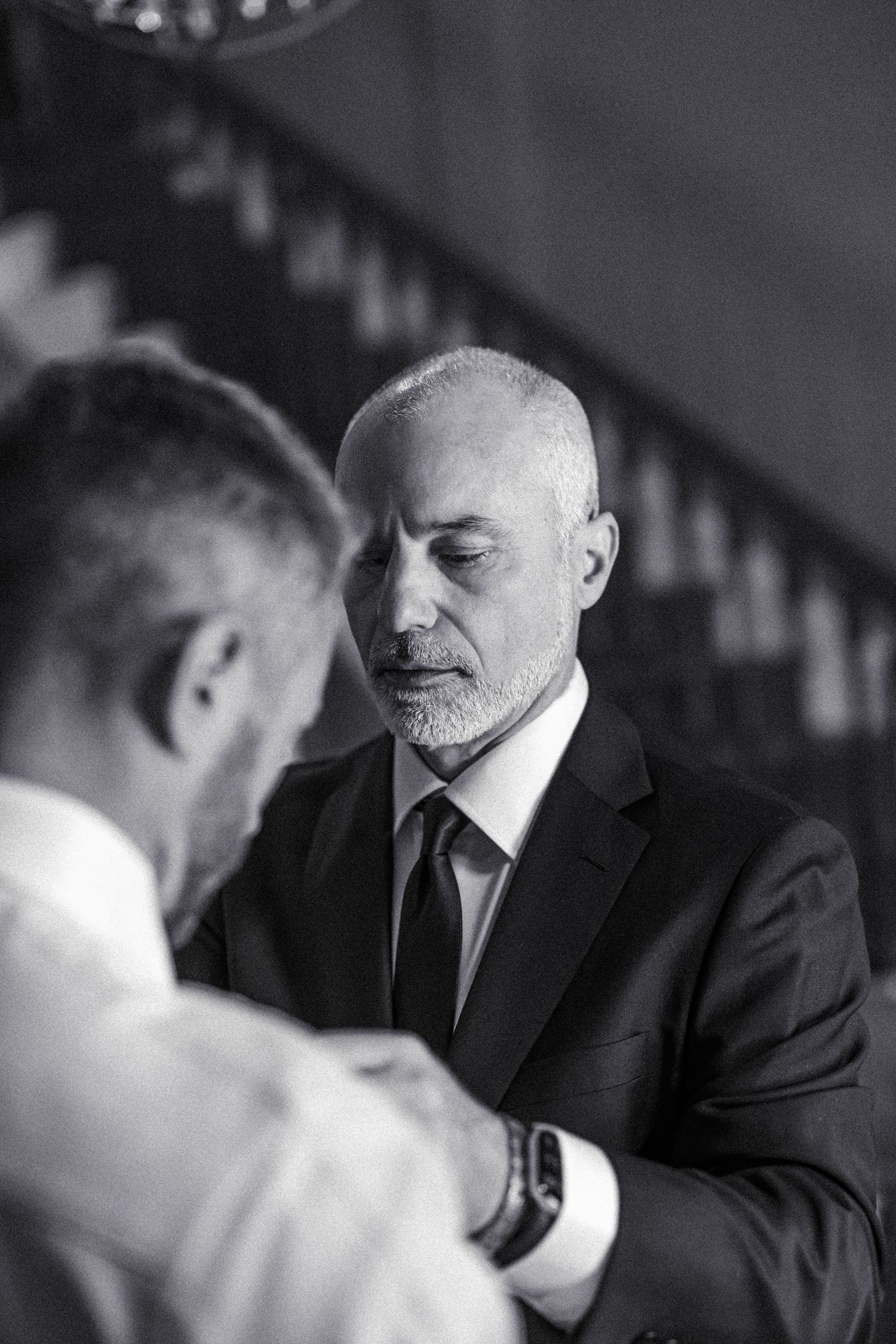 Black and white photo of two men in suits shaking hands at a formal event.