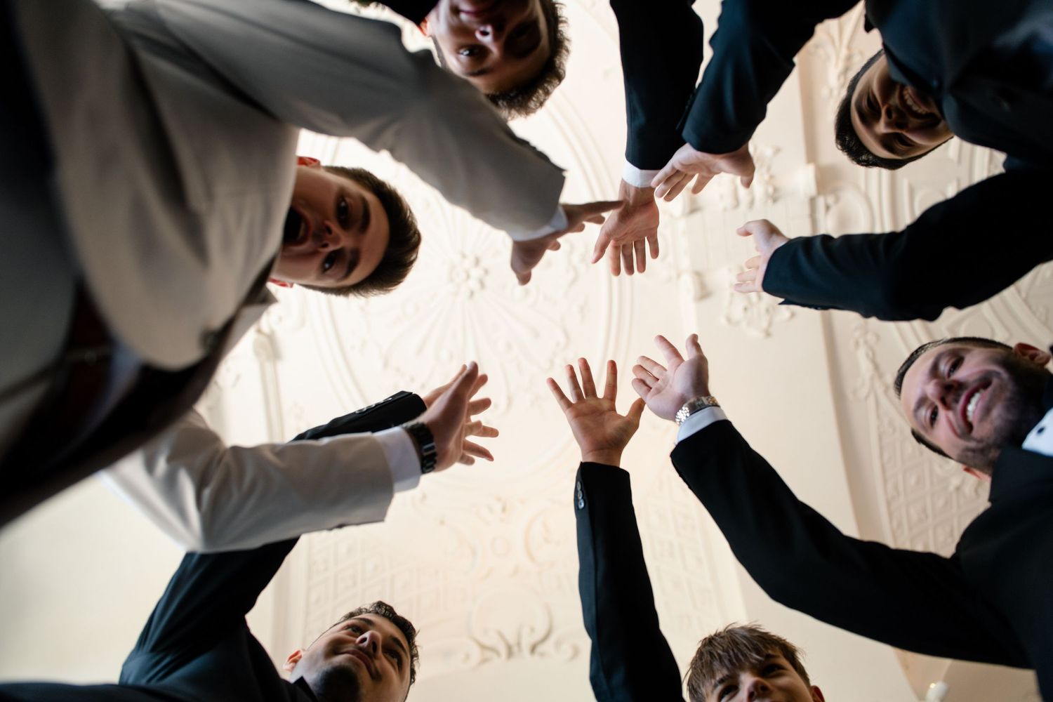 Overhead view of people forming a circle with their hands joined together.