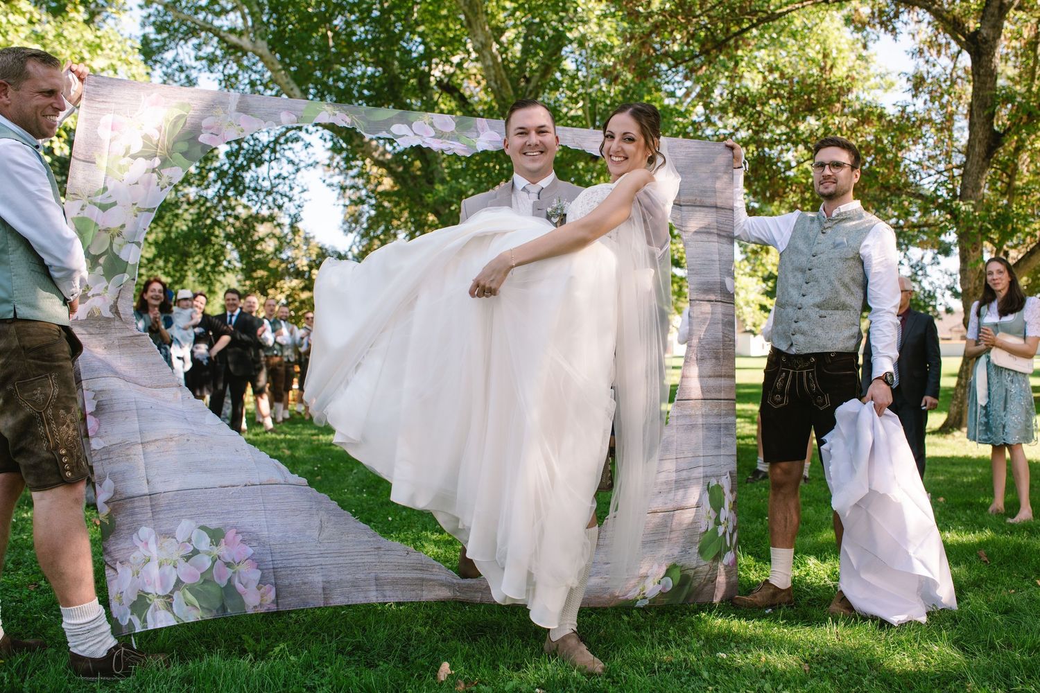Wedding couple walking and dancing together on a sunlit garden path.