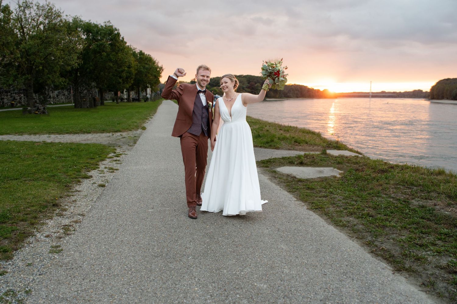 Couple takes romantic sunset walk along lakeside path.