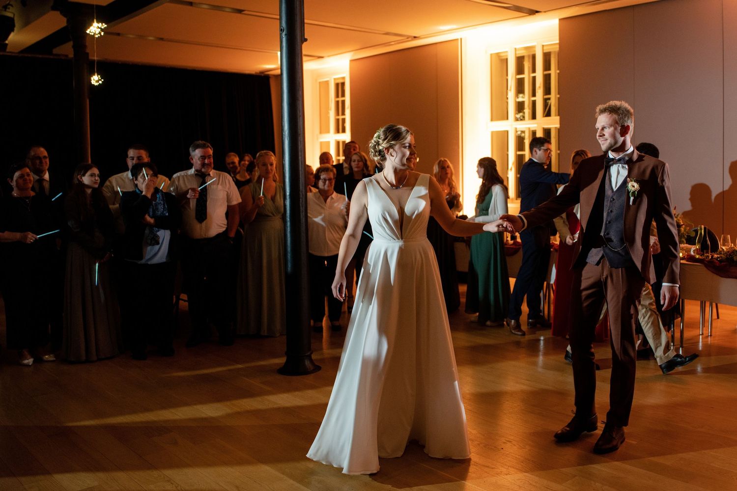Wedding reception dance floor with warm lighting and guests celebrating.