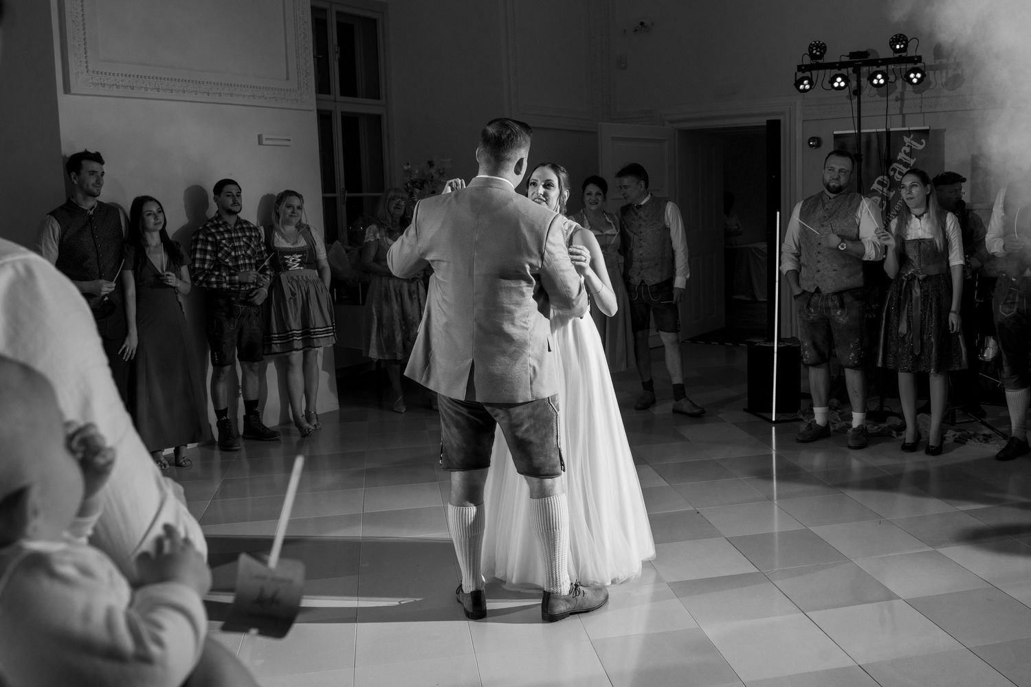 A couple shares their first dance at a wedding reception in an elegant indoor venue.