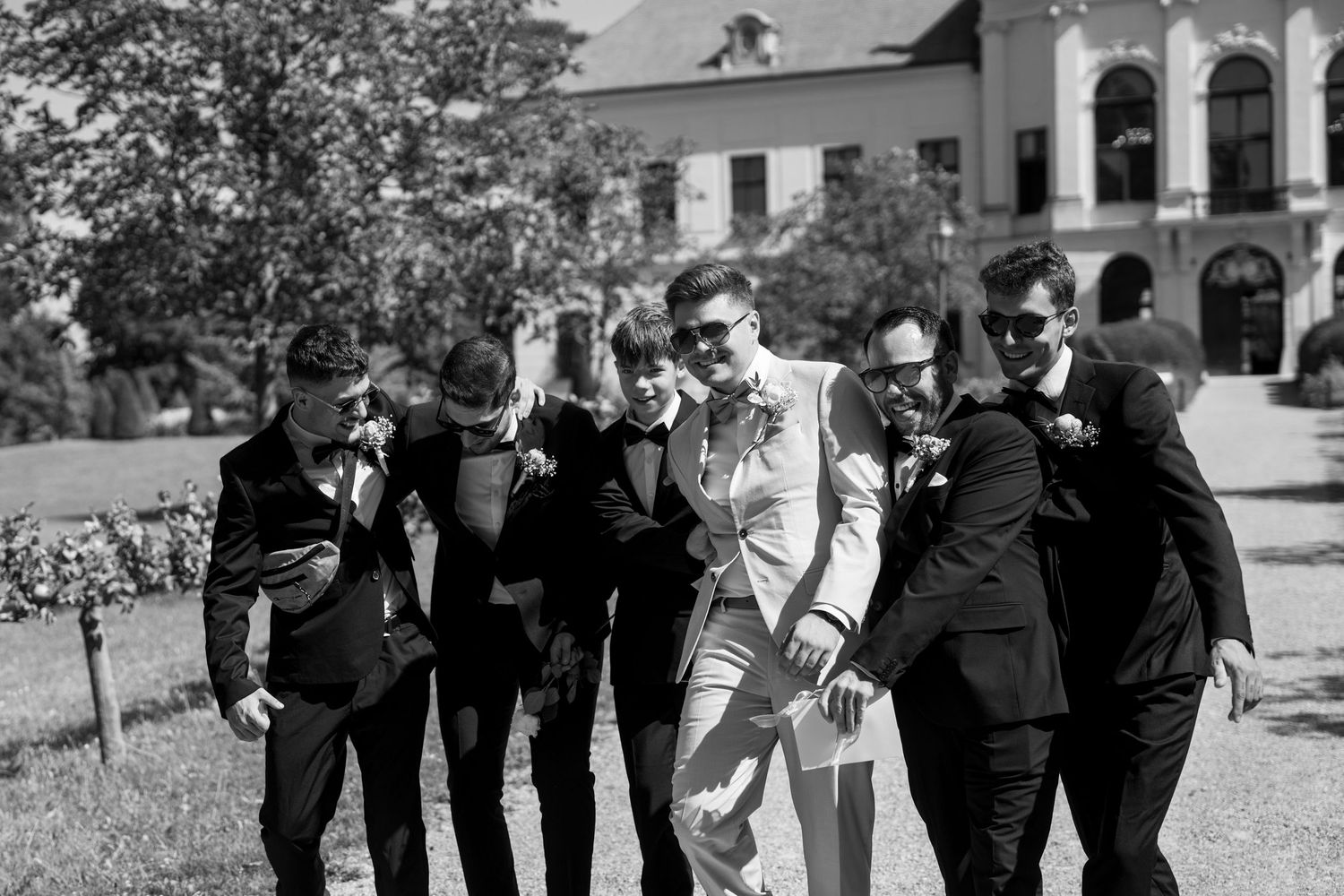 Black and white photo of wedding party lined up in front of classical building.