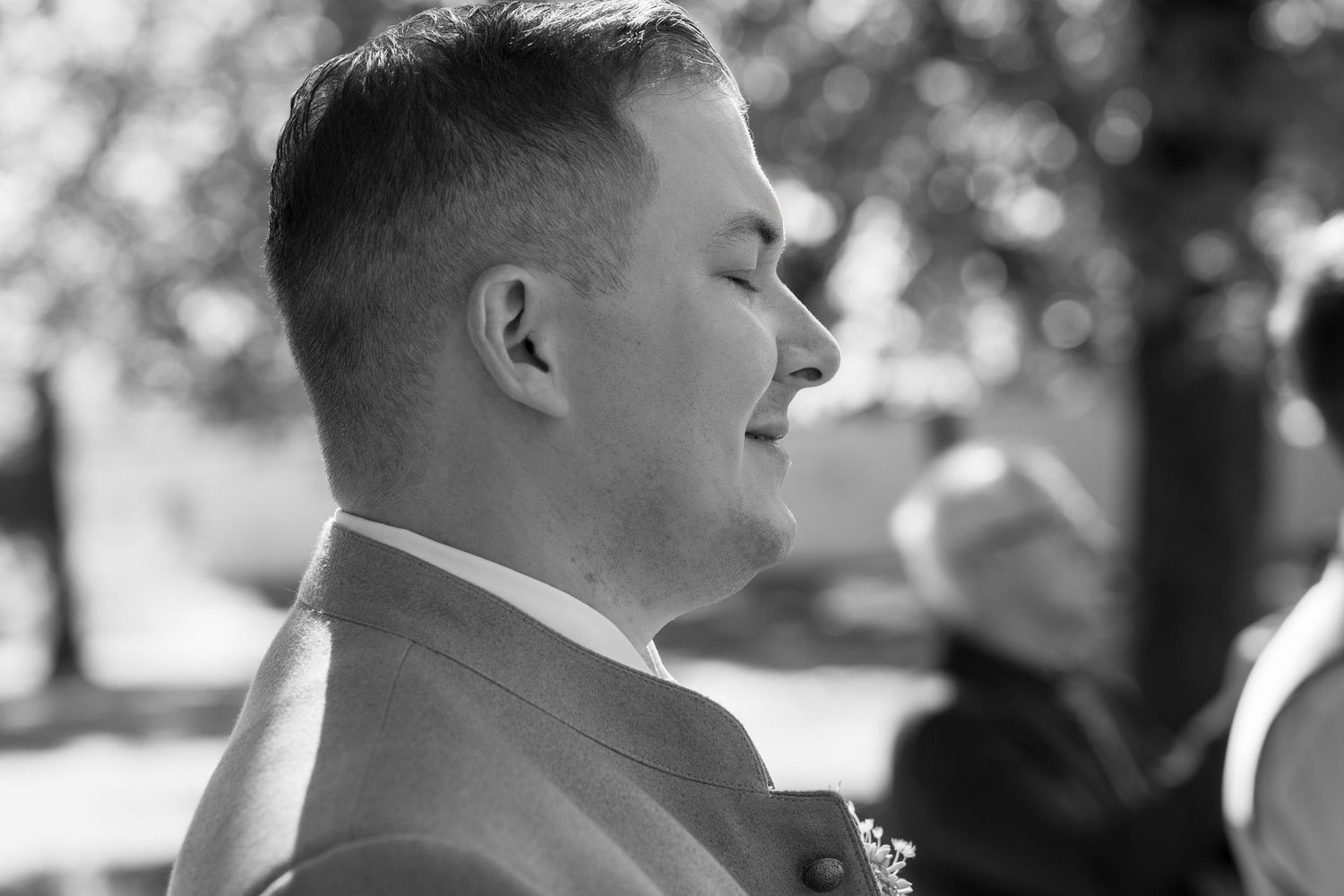 Black and white profile shot during outdoor wedding ceremony.