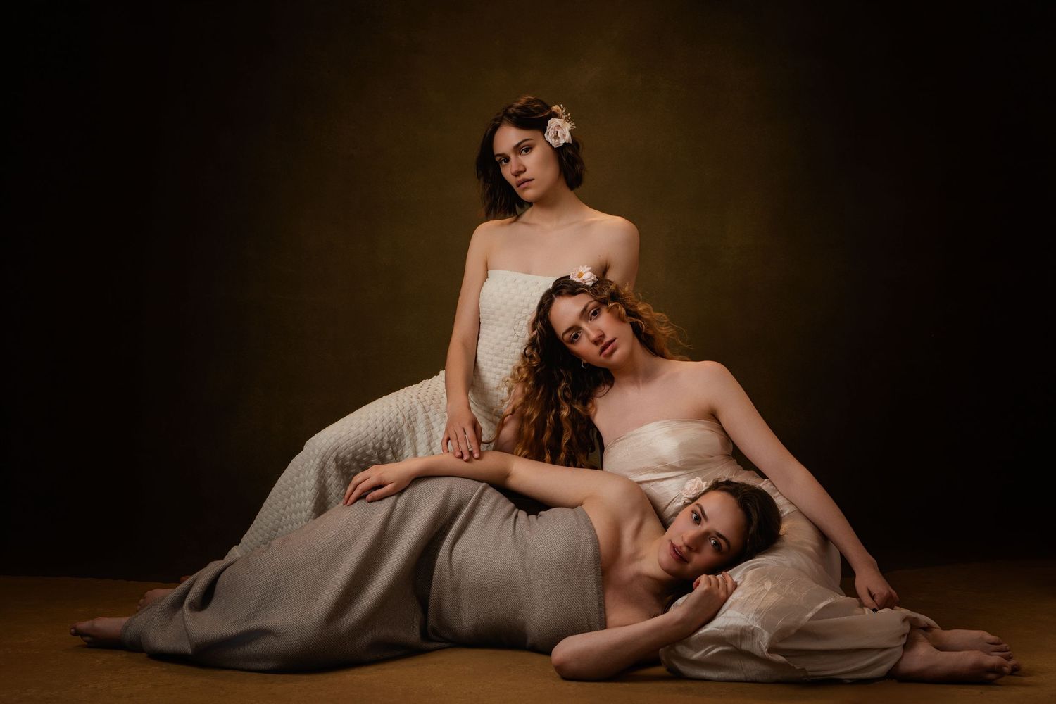 Artistic fashion portrait series showing model in elegant poses against dark moody backdrop.