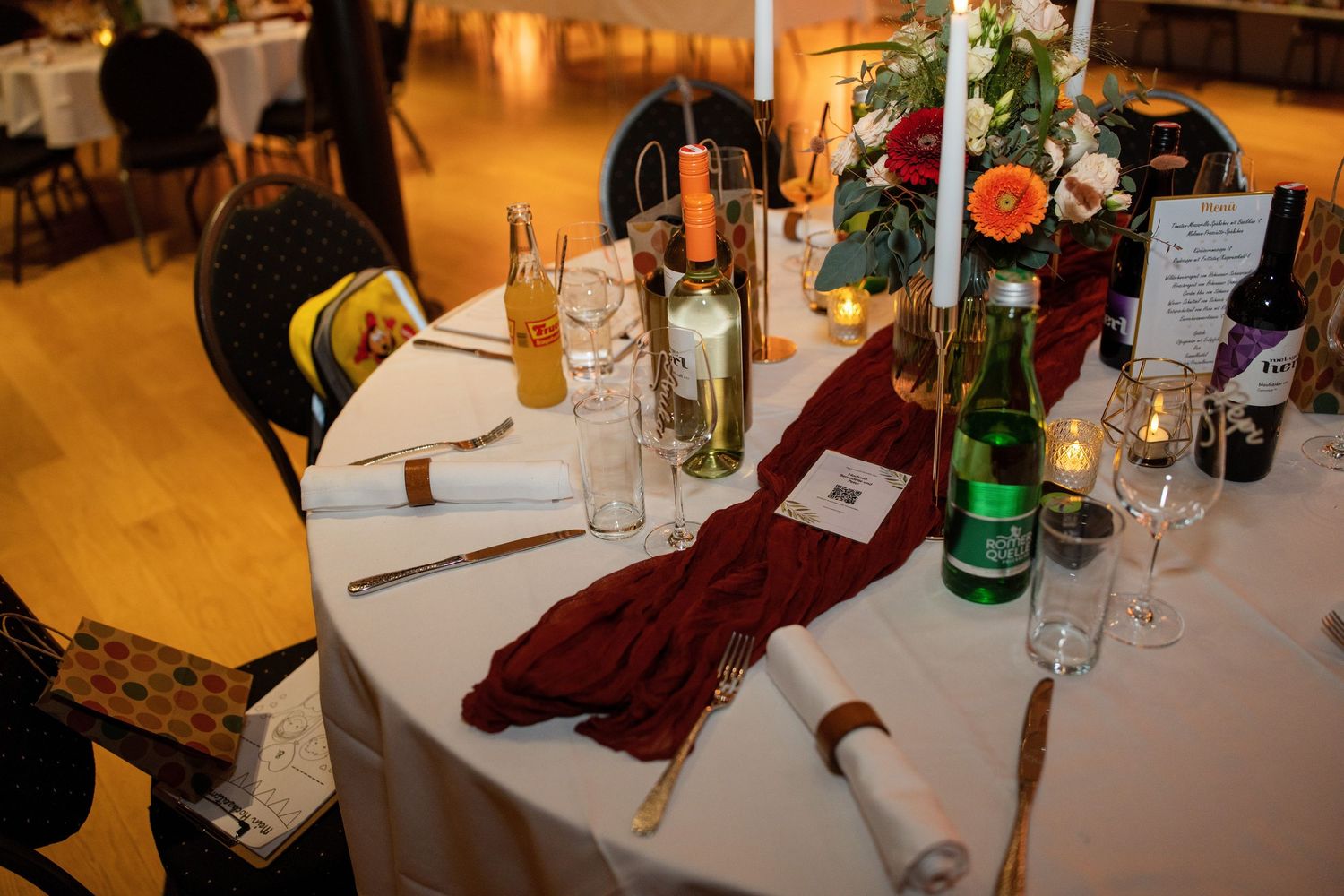 Wedding reception table settings with candlelight and wine glasses.