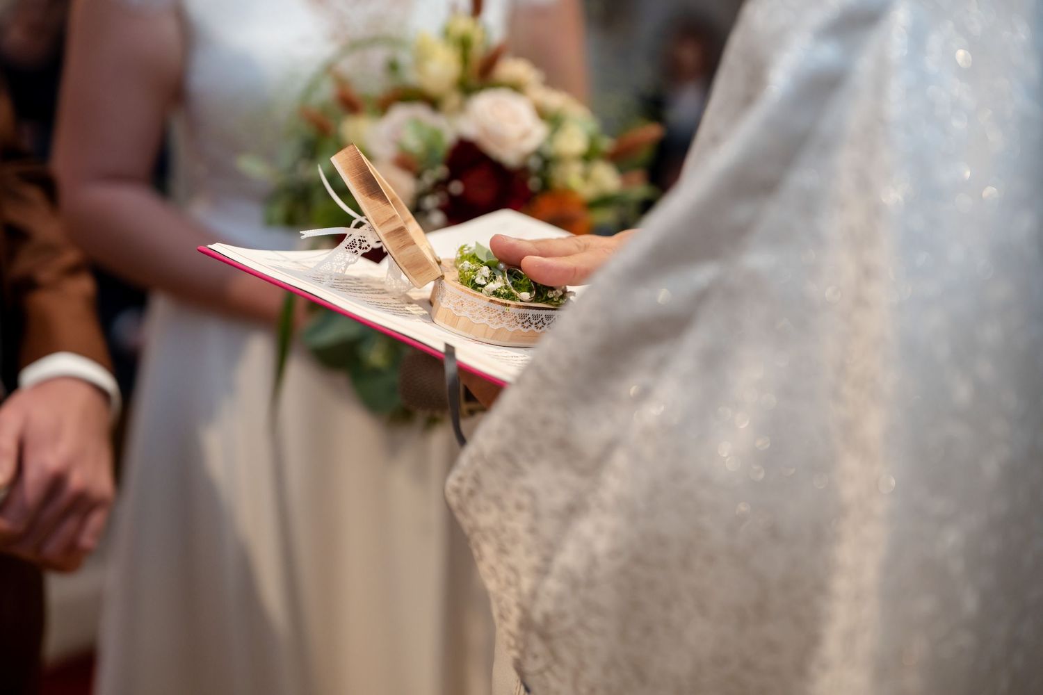 Close-up of white wedding dress details with lace and floral elements.