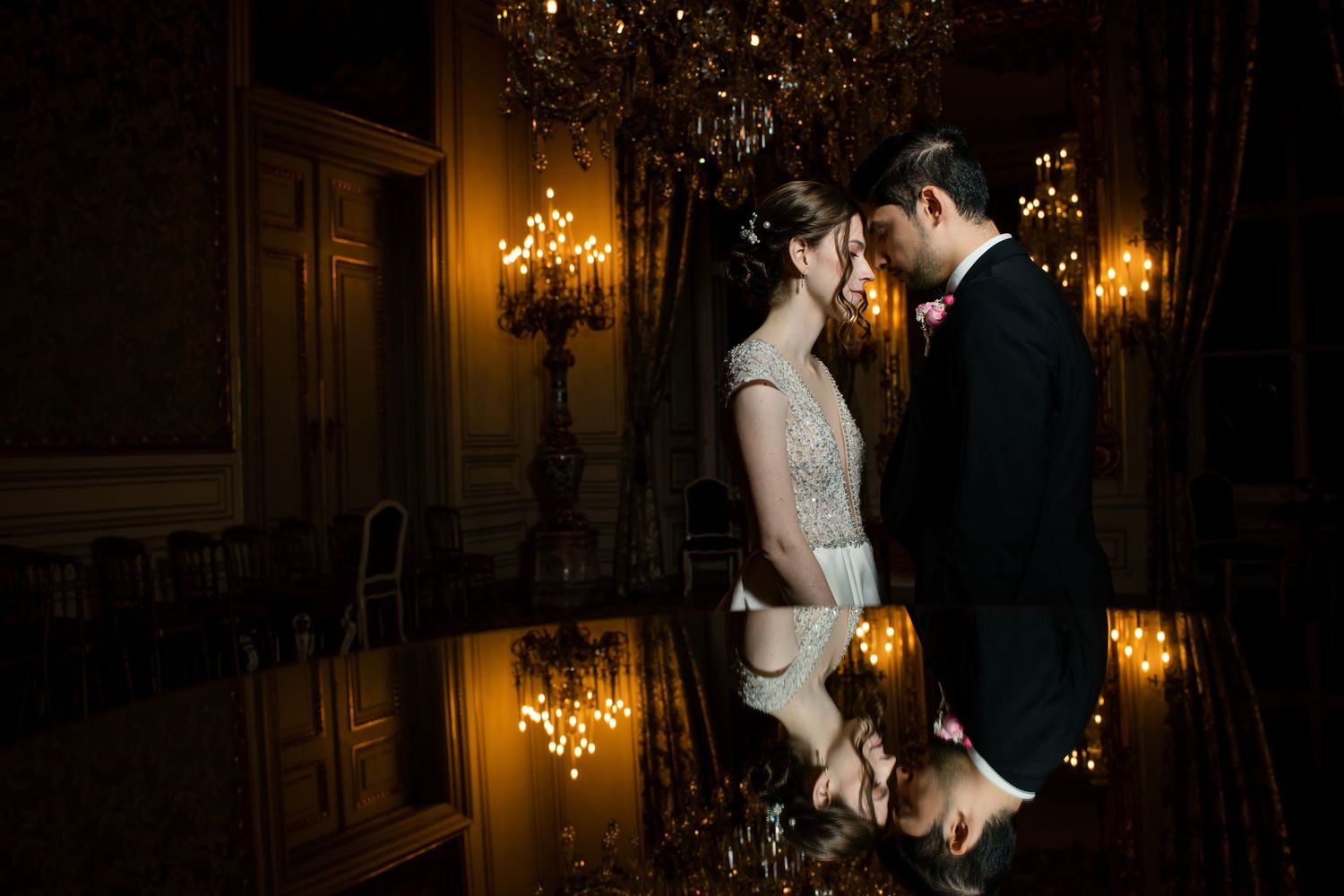 A romantic wedding photo series showing a couple in formal attire embracing in a warmly lit elegant hallway.