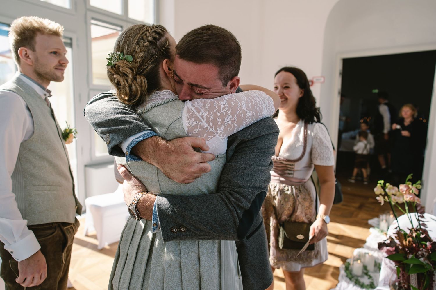 Guests share warm embraces and congratulations during an intimate wedding reception.
