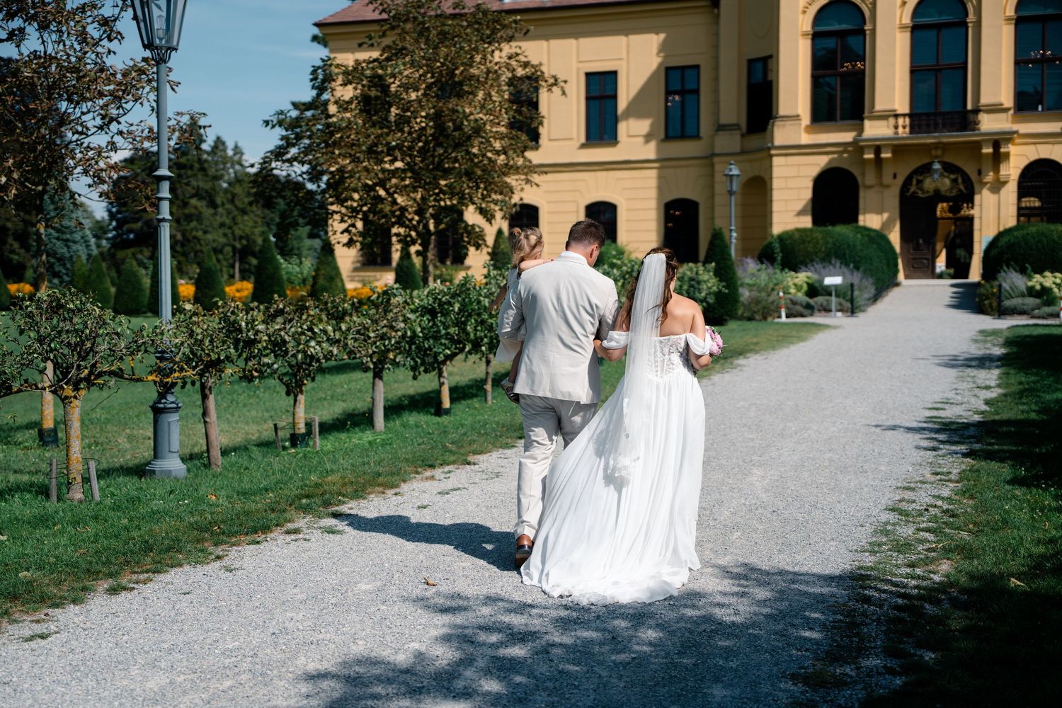 Elegant stone building provides backdrop for outdoor wedding photographs.