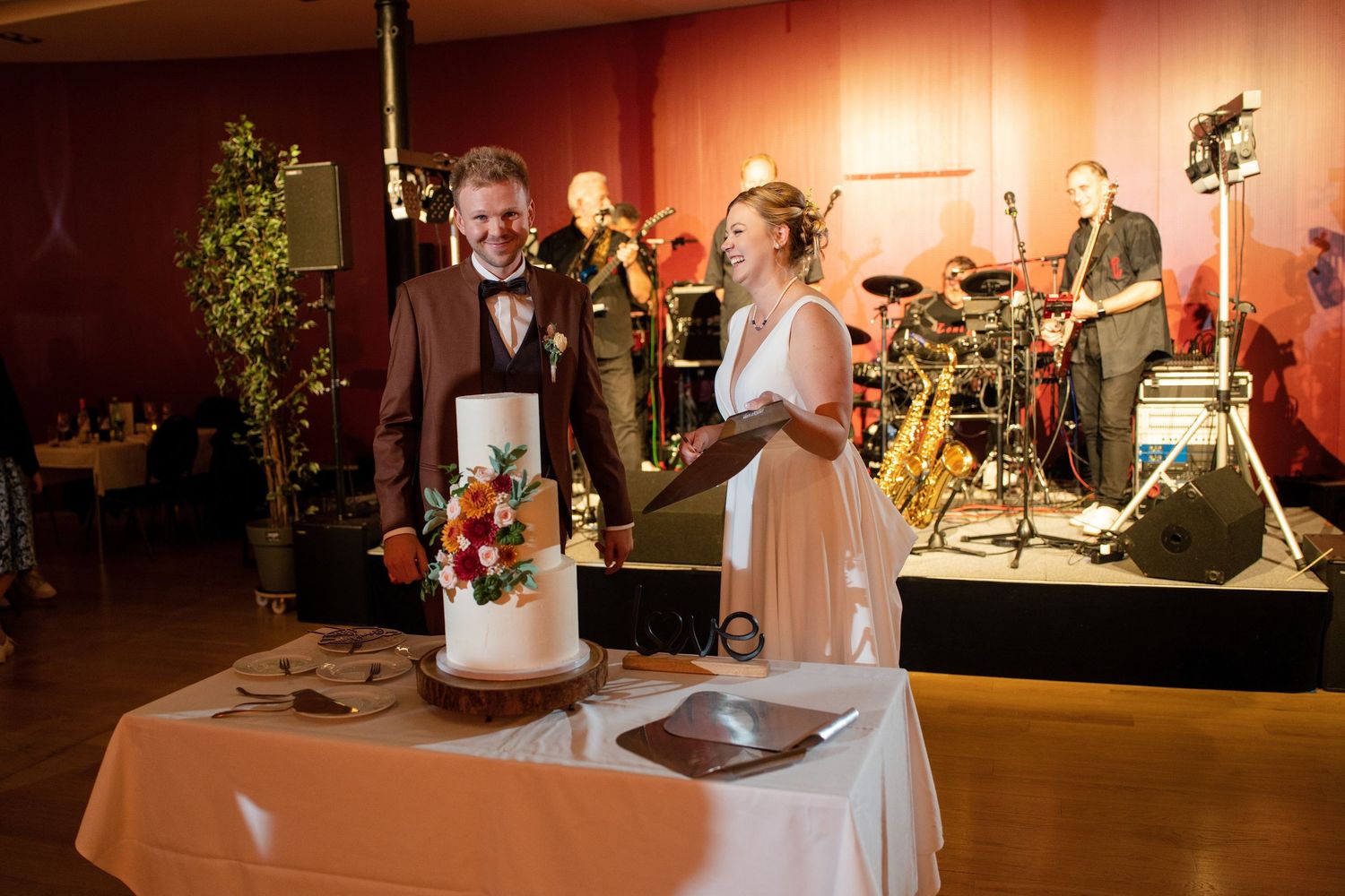 Wedding reception venue with warm lighting and decorative table settings in evening ambiance.