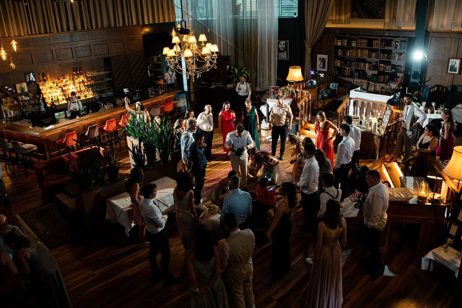Dark and moody wide shot of a wedding reception venue filled with guests.