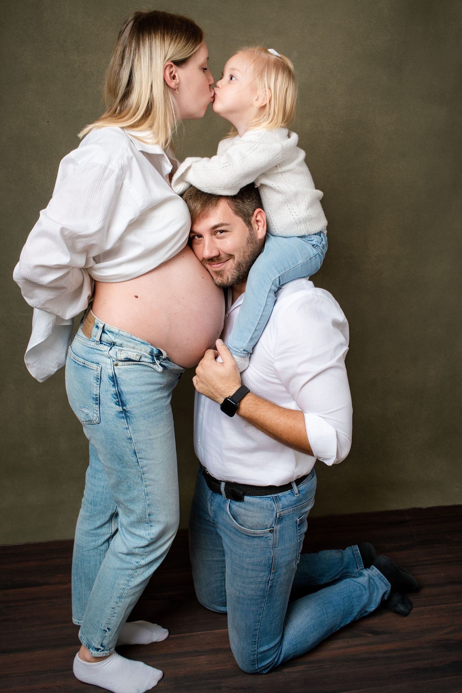 Sweet family interactions captured during professional photo shoot in matching casual attire.