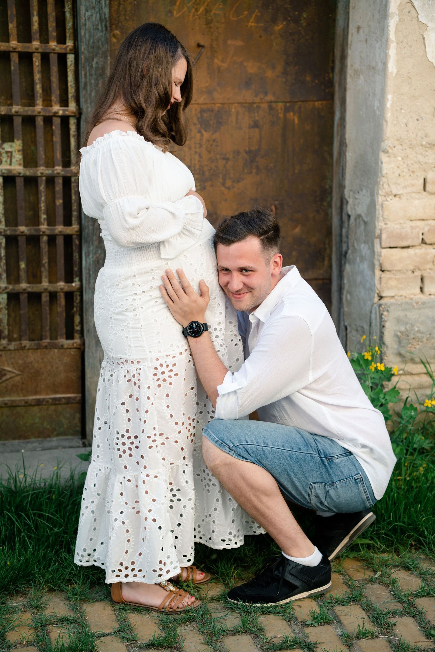 A series of progressive photos showing a couple in white clothing posing against a rustic stone wall background.