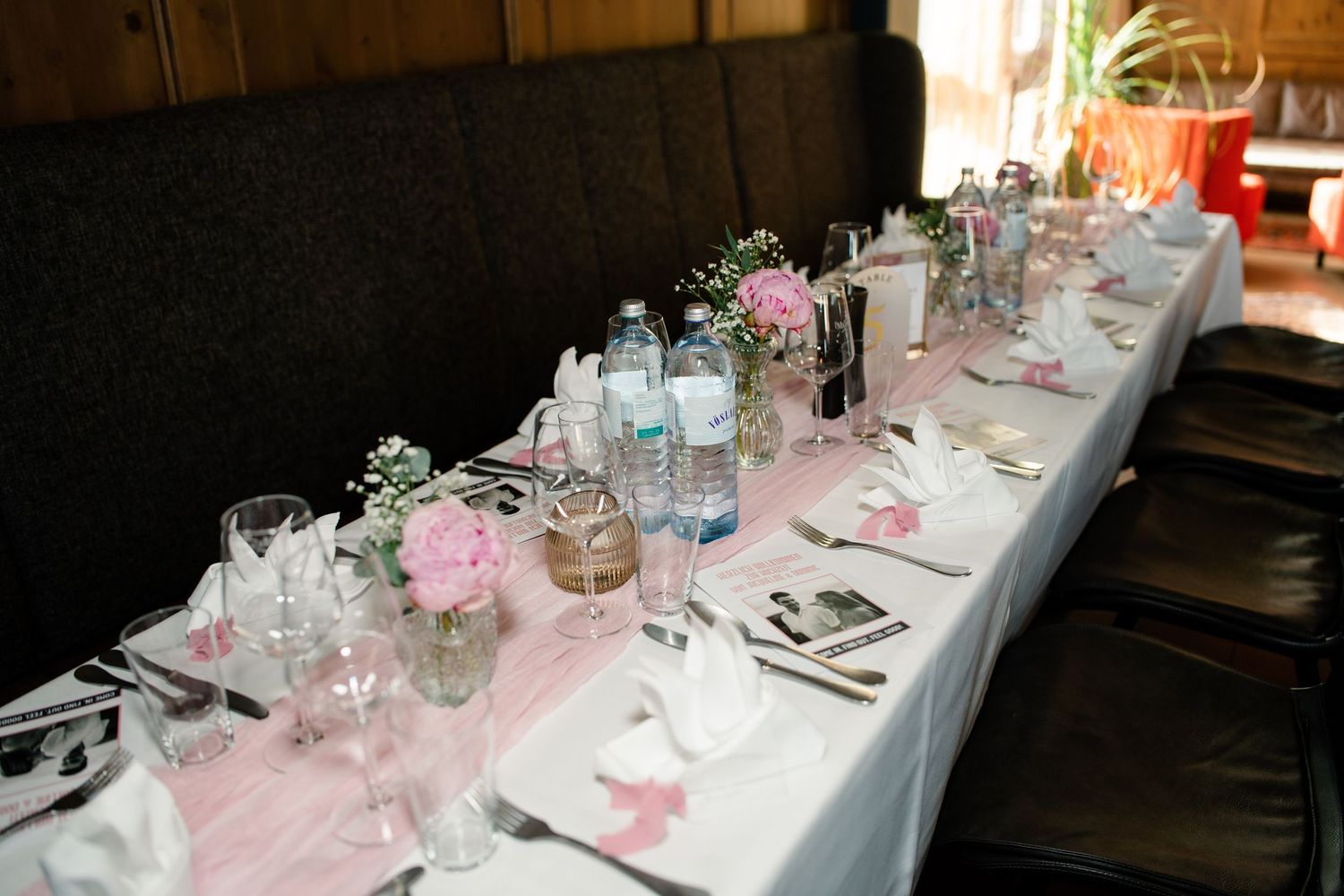 Elegant wedding reception tables decorated in pink and white with place settings.