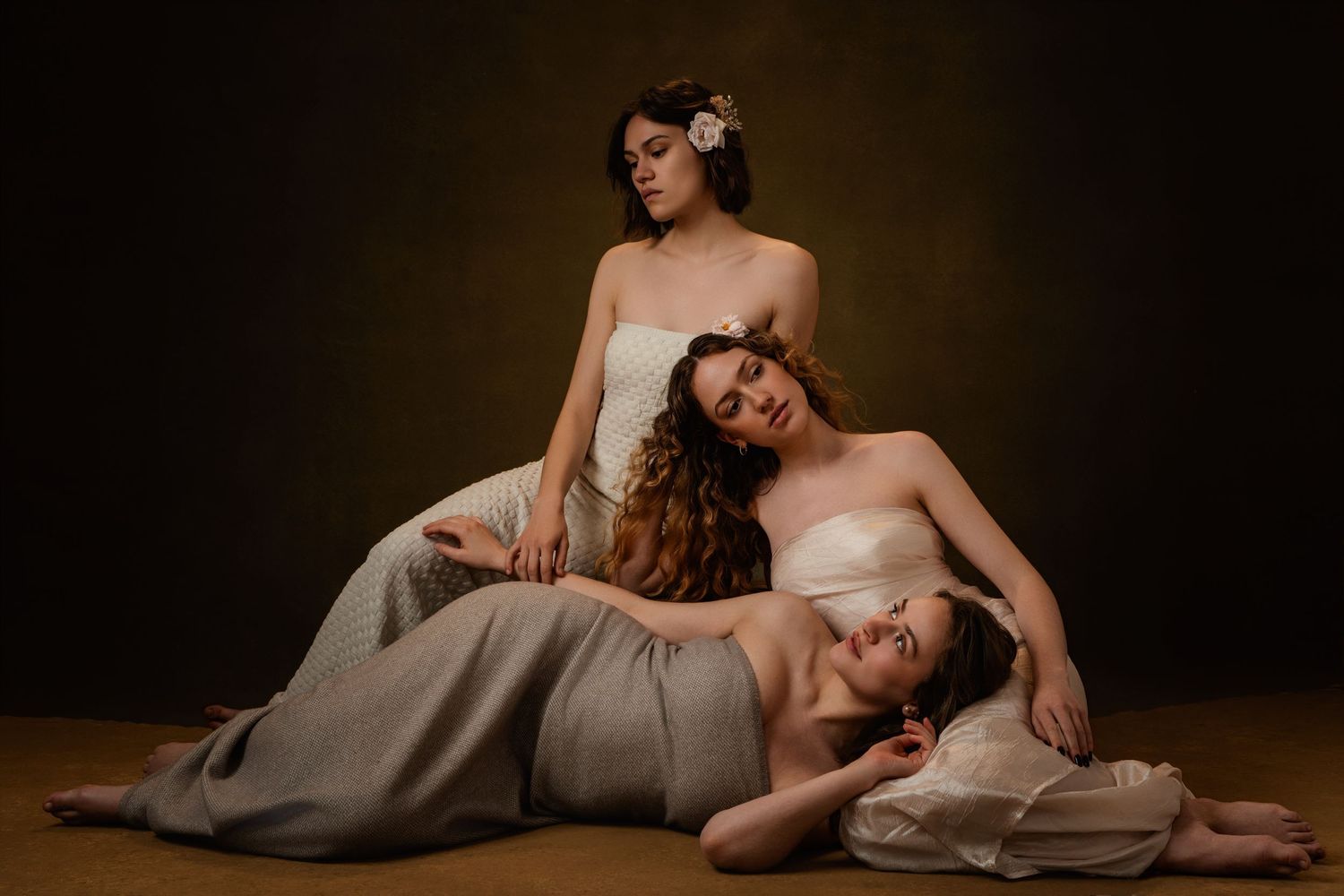 Artistic portrait series of figures reclining in dramatic poses against dark backgrounds.